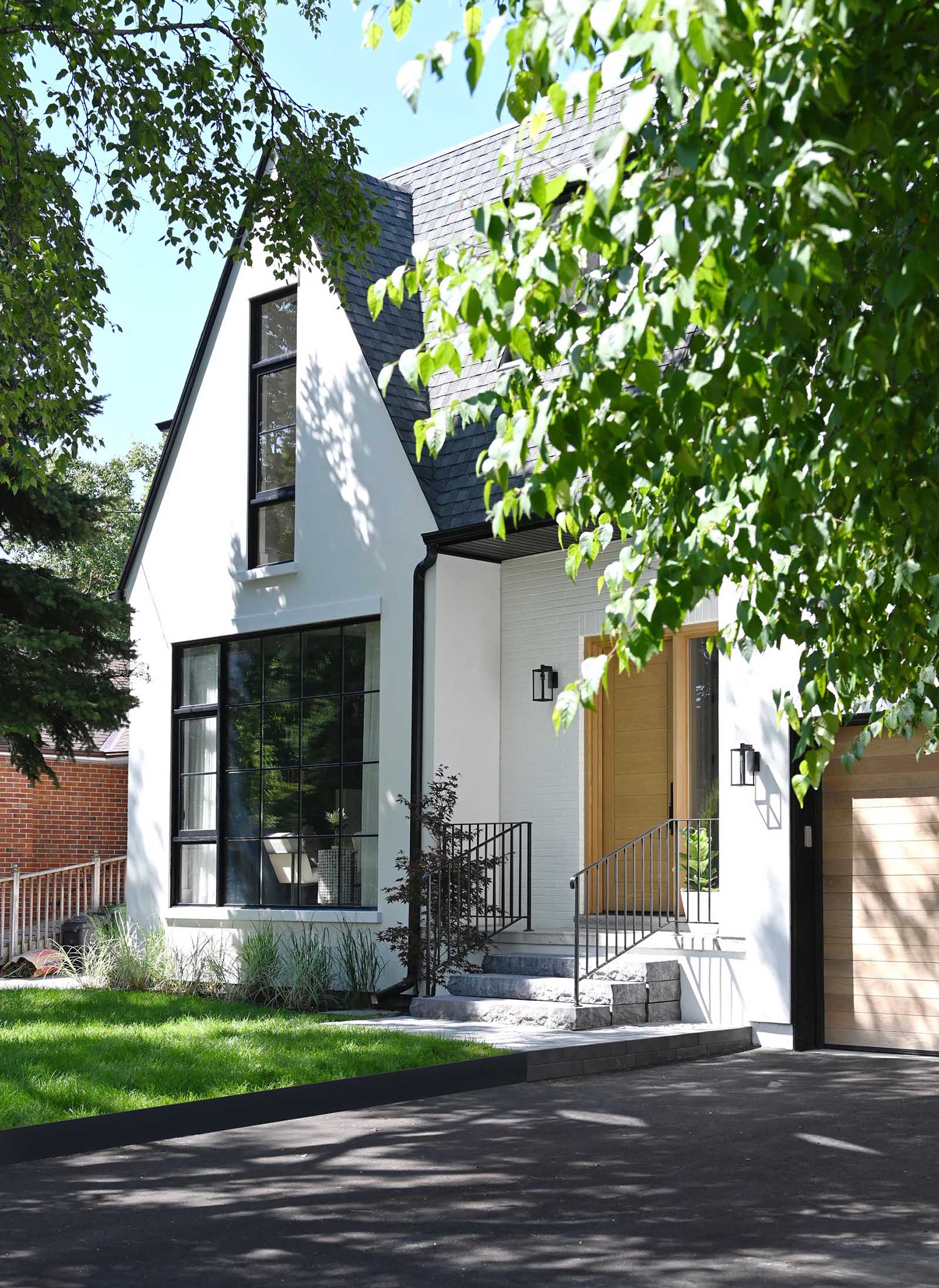 This contemporary home was inspired by farmhouse living, with the white exterior accented by natural white oak wood to add a warm welcome and a hint at what lies beyond.