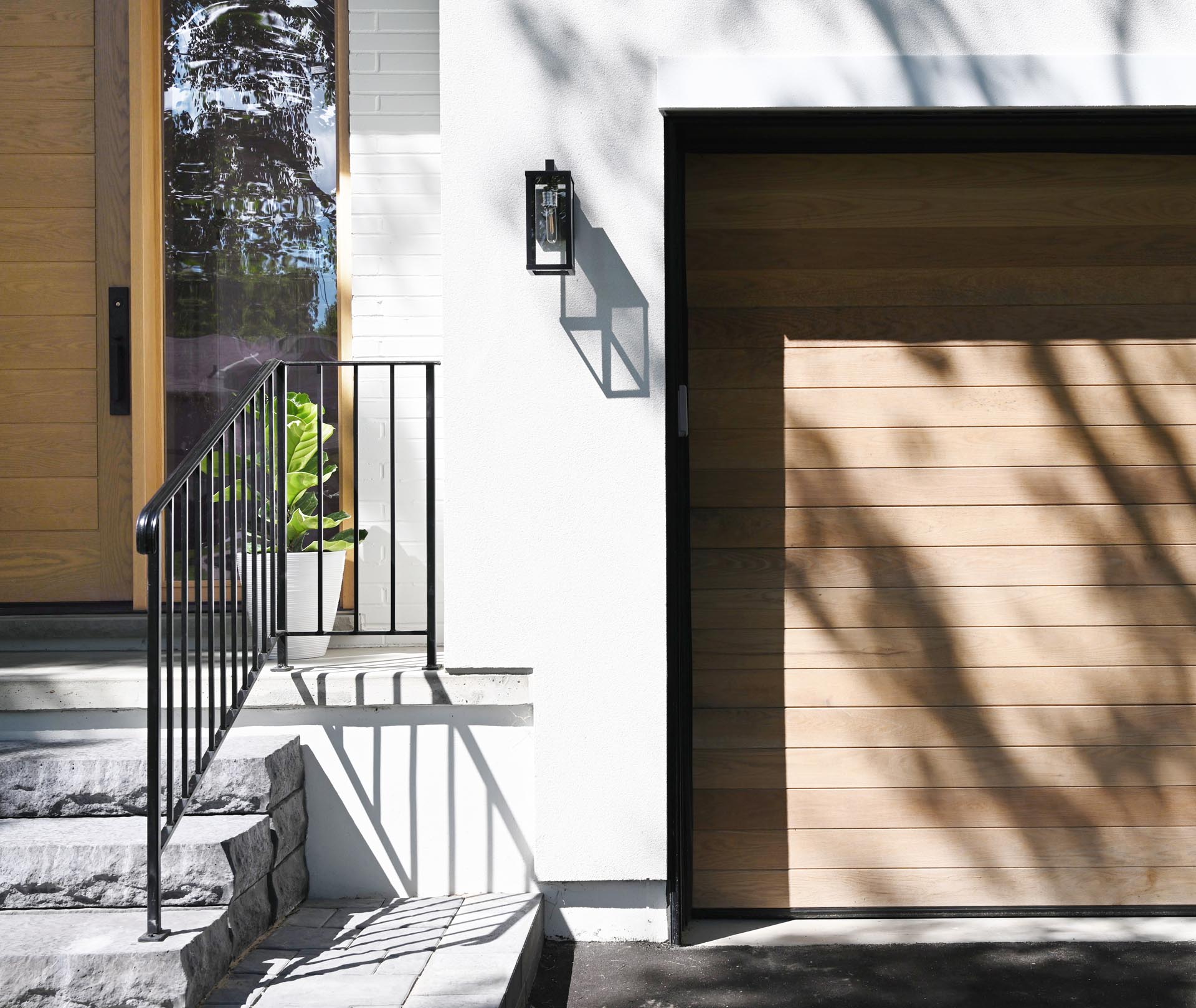 This contemporary home was inspired by farmhouse living, with the white exterior accented by natural white oak wood to add a warm welcome and a hint at what lies beyond.