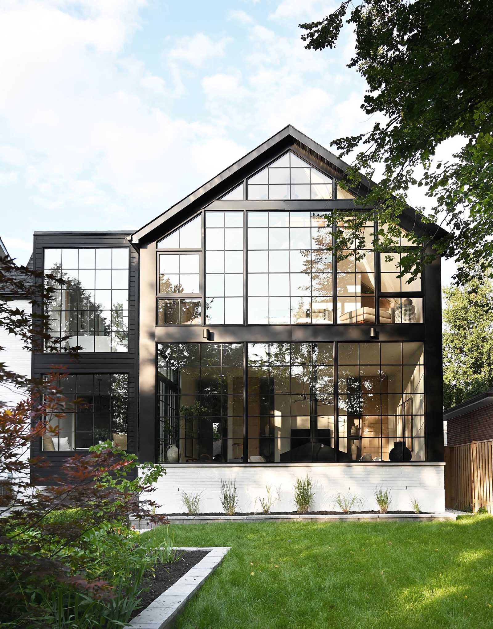 This contemporary home includes a back wall made up of large format loft style windows which are a contrast to the crisp material palette found throughout the home.
