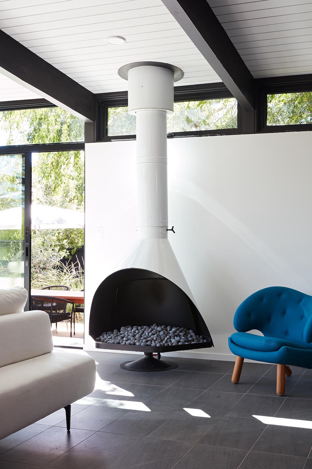 A remodeled living room with a Malm fireplace, black accents, and white walls.