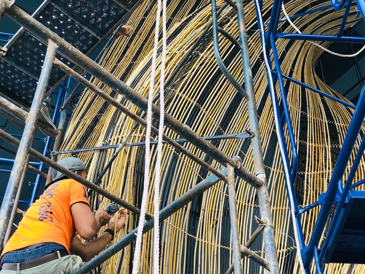 MAKING OF - A modern restaurant with a glass facade that showcases flowing rattan sculptures inside.