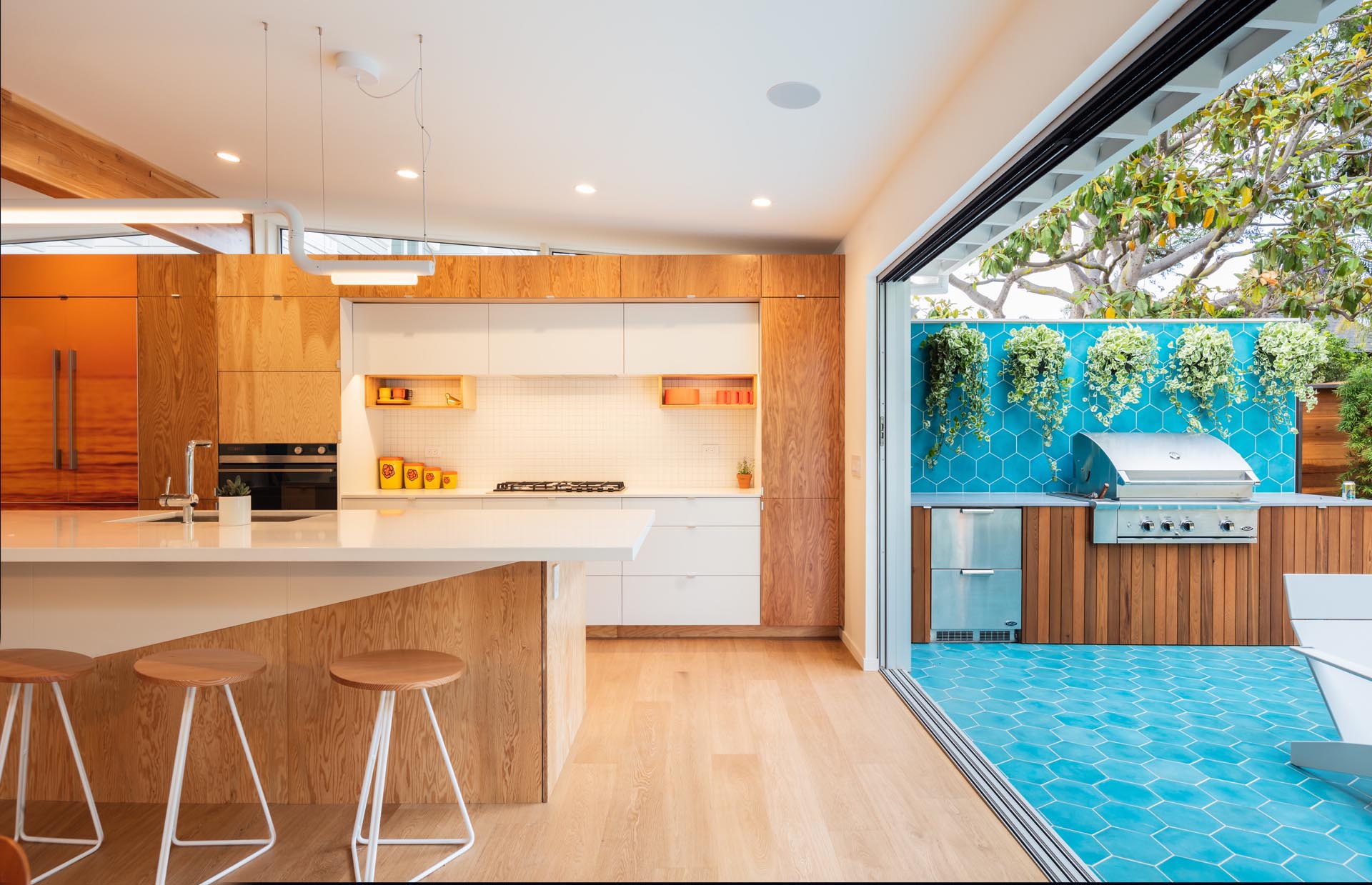 A large sliding door opens to the outdoor kitchen and yard.