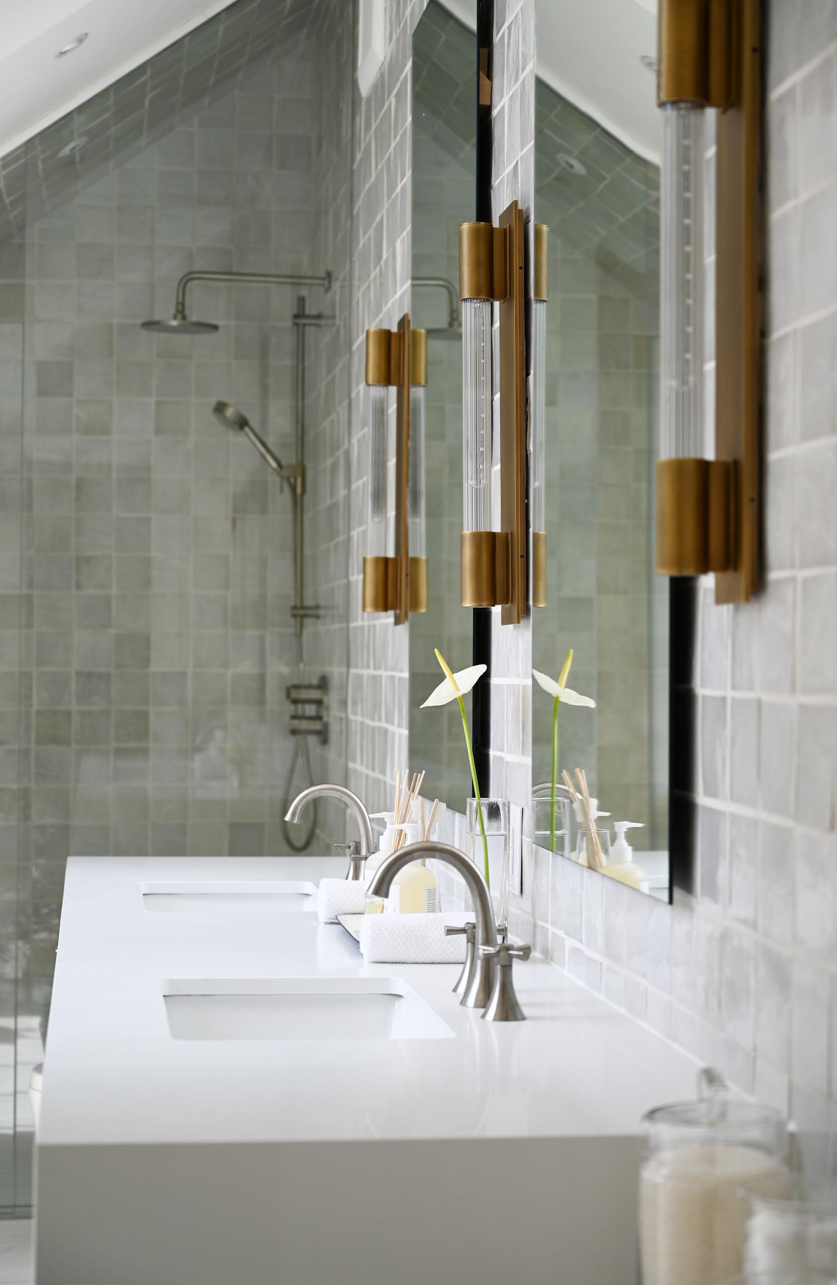 This modern white marbled spa-like bathroom includes a windowed alcove for the freestanding tub, metallic hardware, and wood accents.