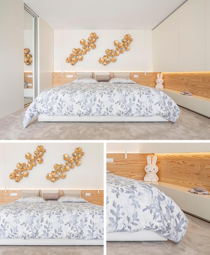 Bedroom Lighting Ideas - A modern white bedroom with a wood headboard that showcases hidden LED lighting.