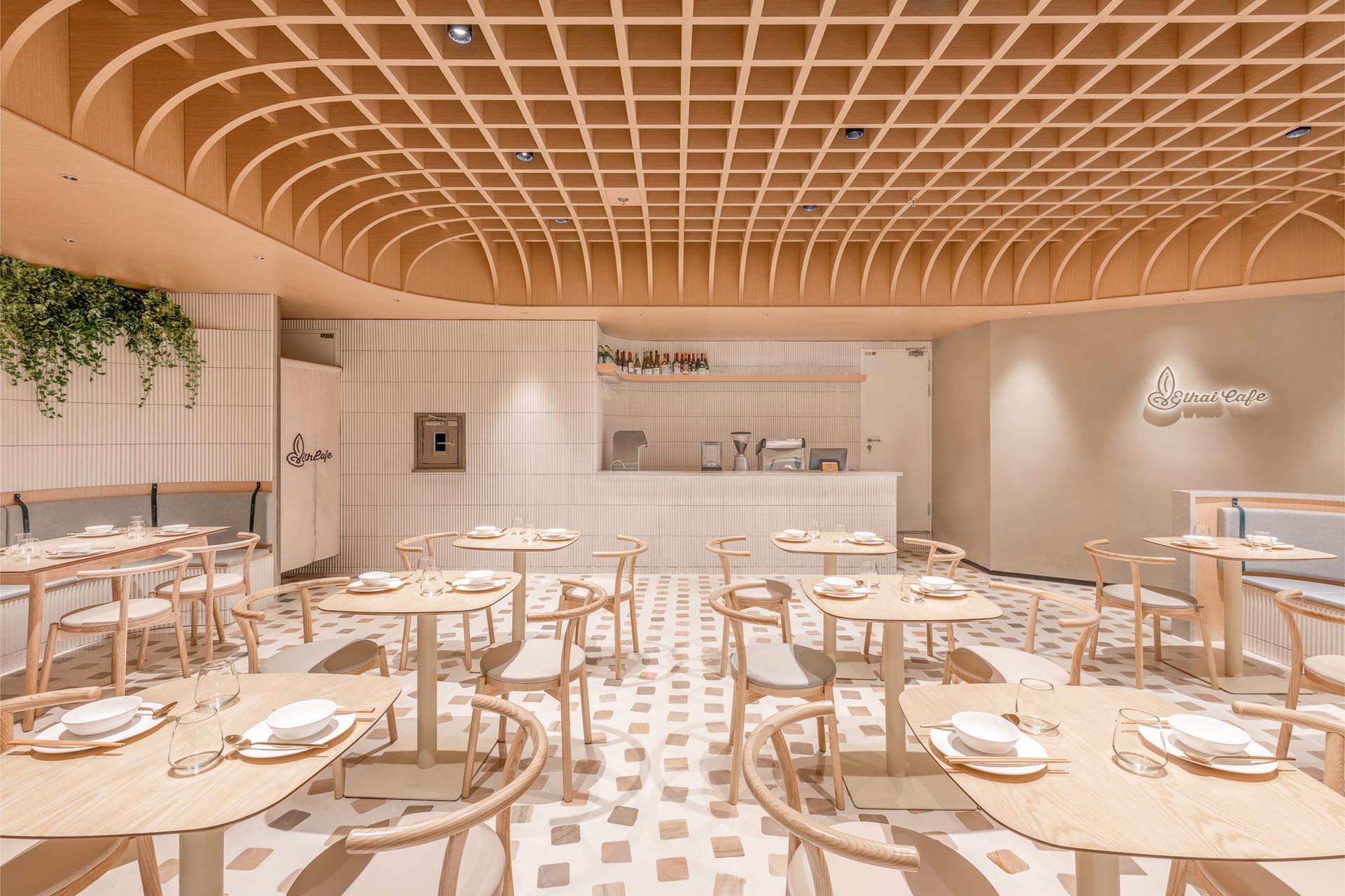 A modern cafe with a design that includes a dome-shaped ceiling, formed by a grid of wooden beams, in which conceals the space’s lighting.