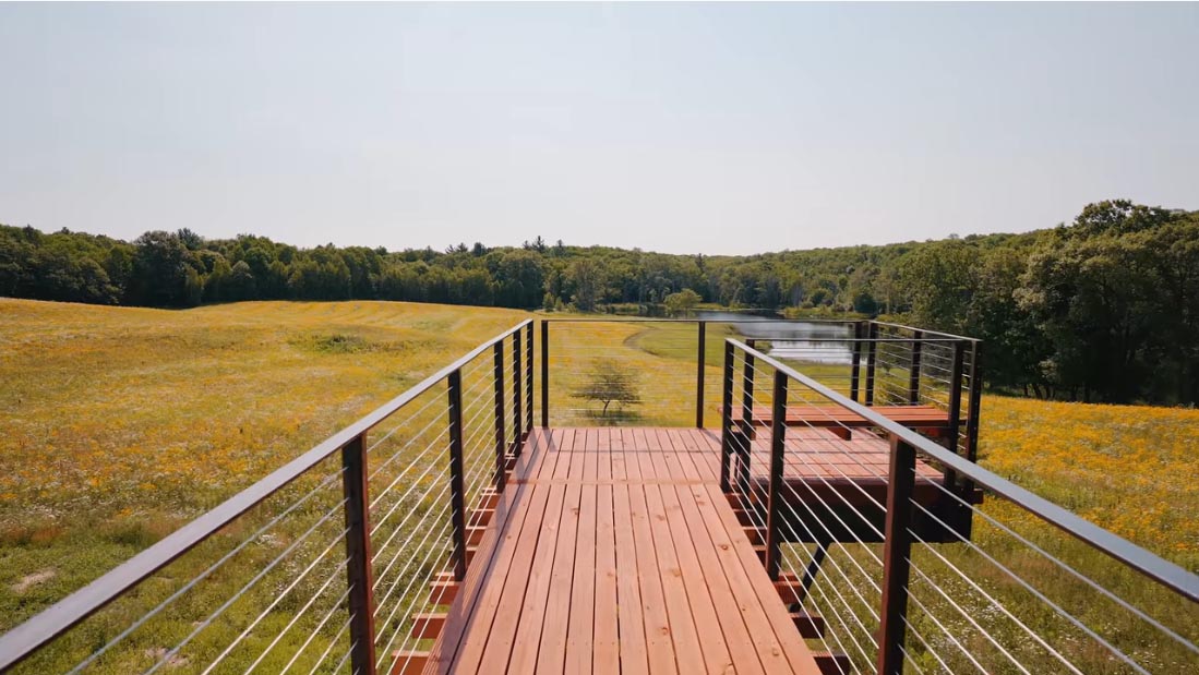 A modern cabin with an elevated deck that cantilevers over the hillside.