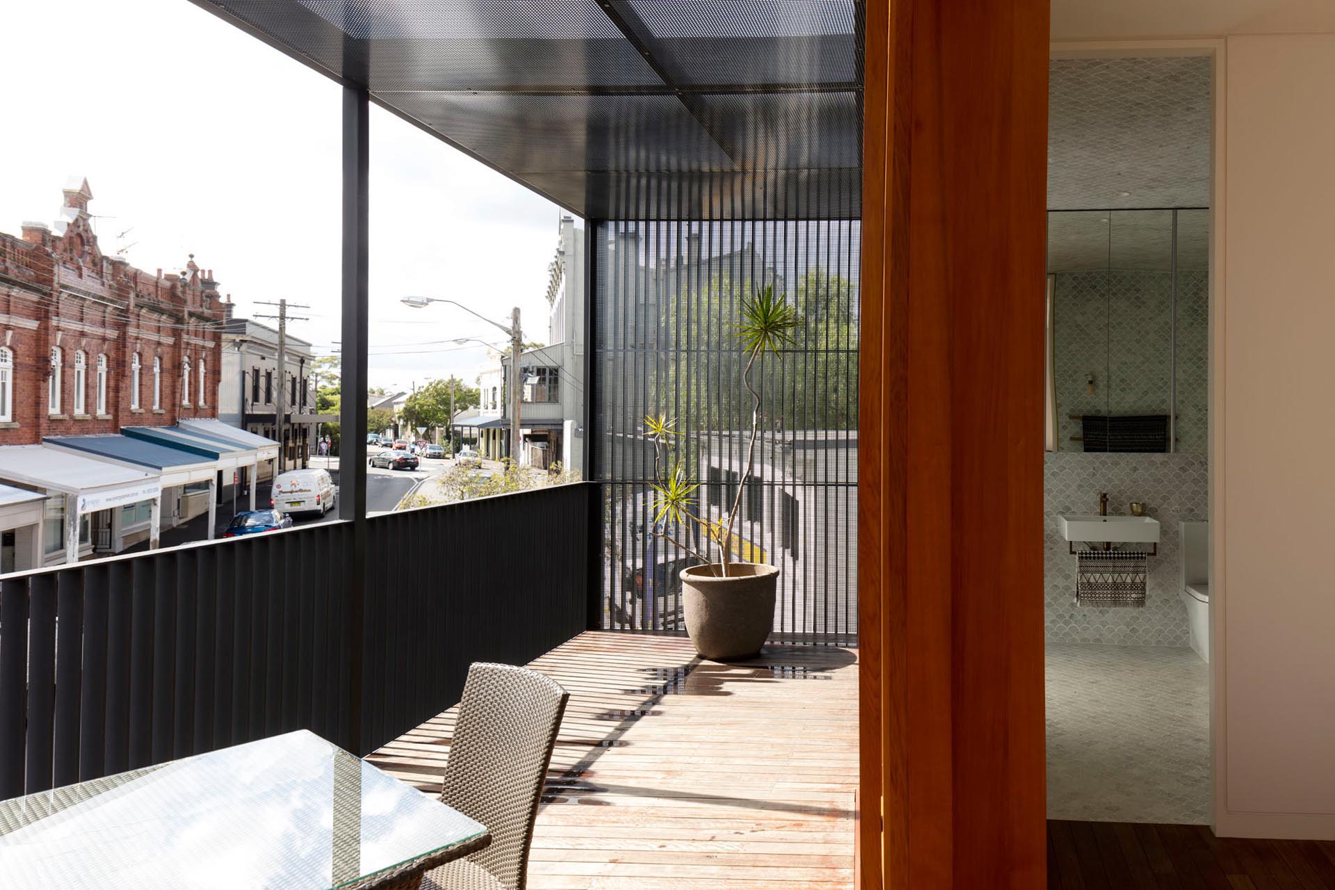 This modern balcony is located at the front of the house and overlooks other buildings on the street.