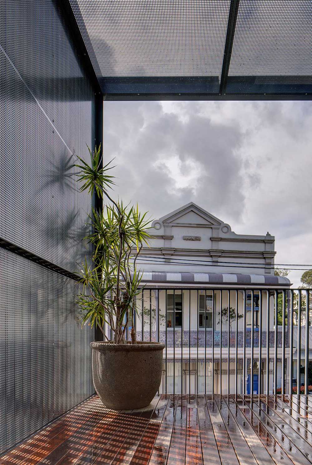 This modern balcony is located at the front of the house and overlooks other buildings on the street.