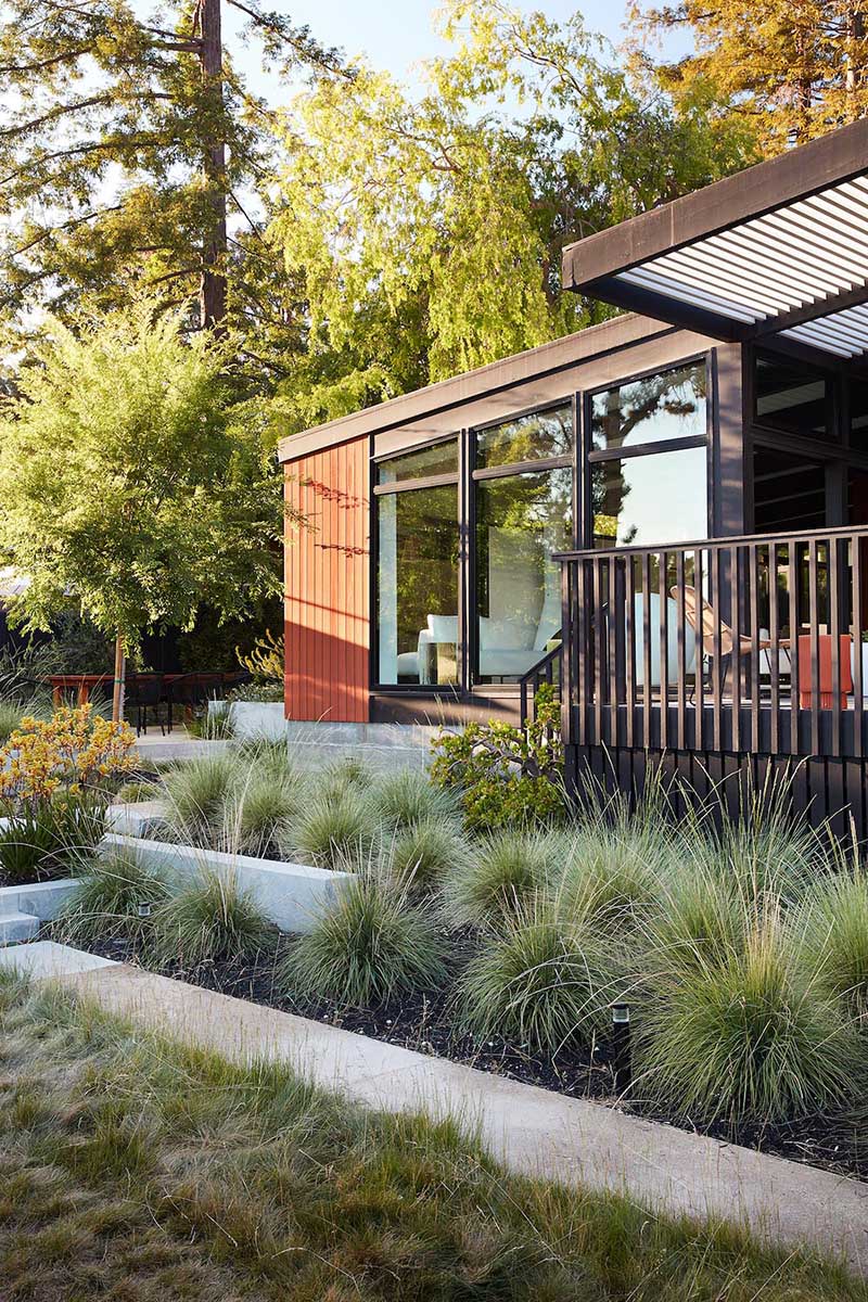 A remodeled mid-century modern house with a mix of relaxing outdoor patio spaces that blend into the native landscaping.