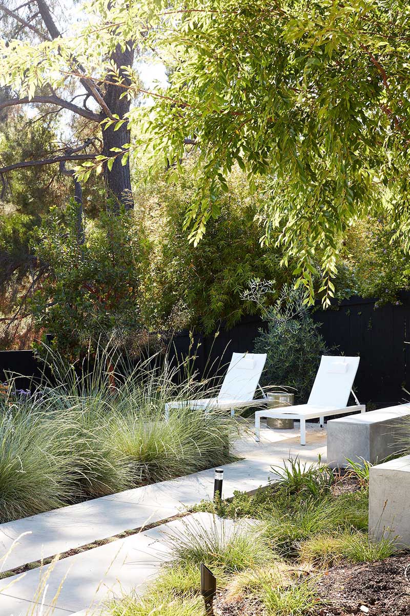 A remodeled mid-century modern house with a mix of relaxing outdoor patio spaces that blend into the native landscaping.