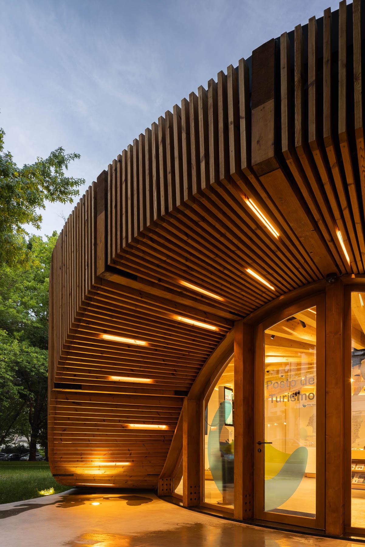 At night, lights line the curves of this modern round building, highlighting the entryway and the reflecting pool.