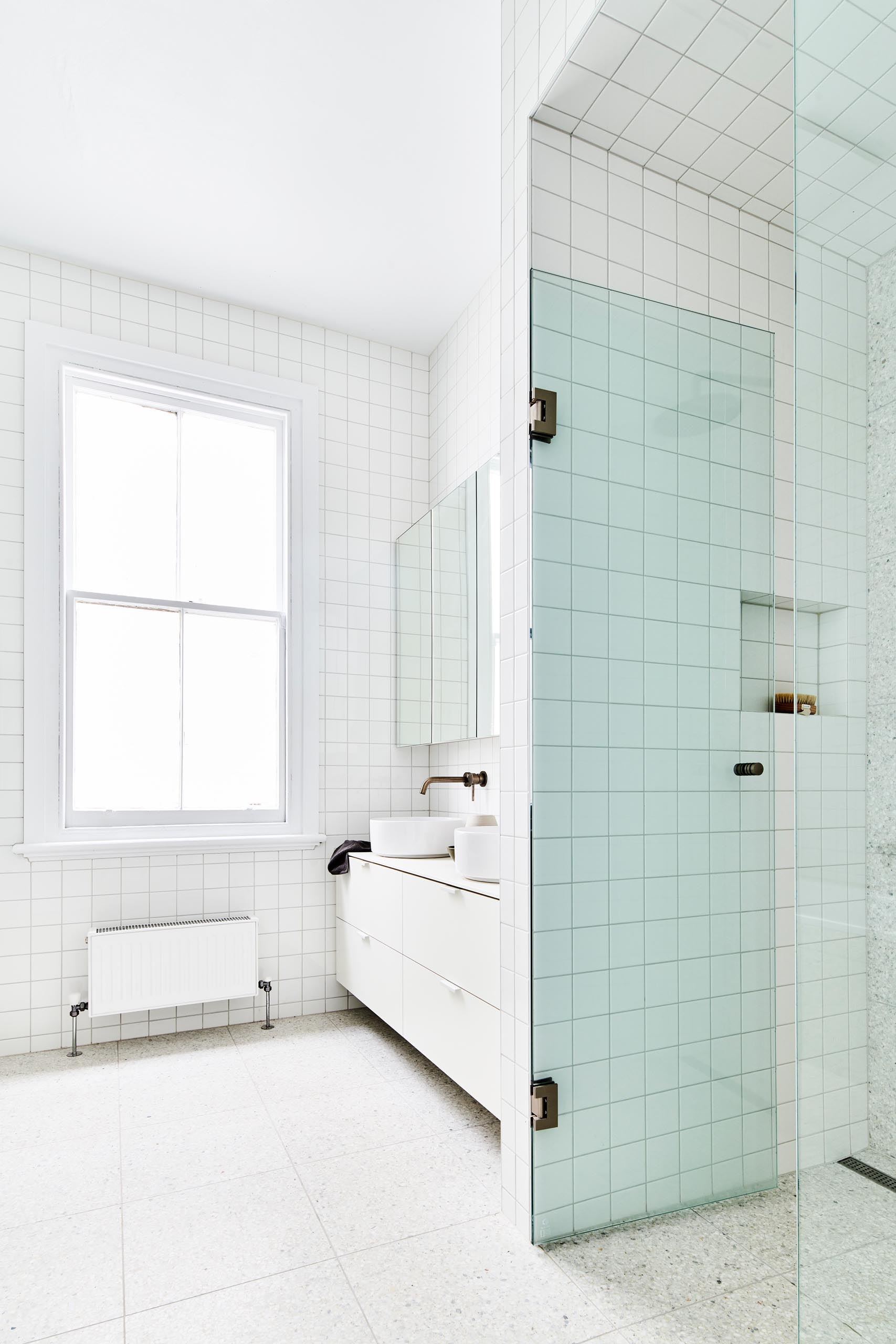 Một phòng tắm hiện đại màu trắng với gạch vuông.