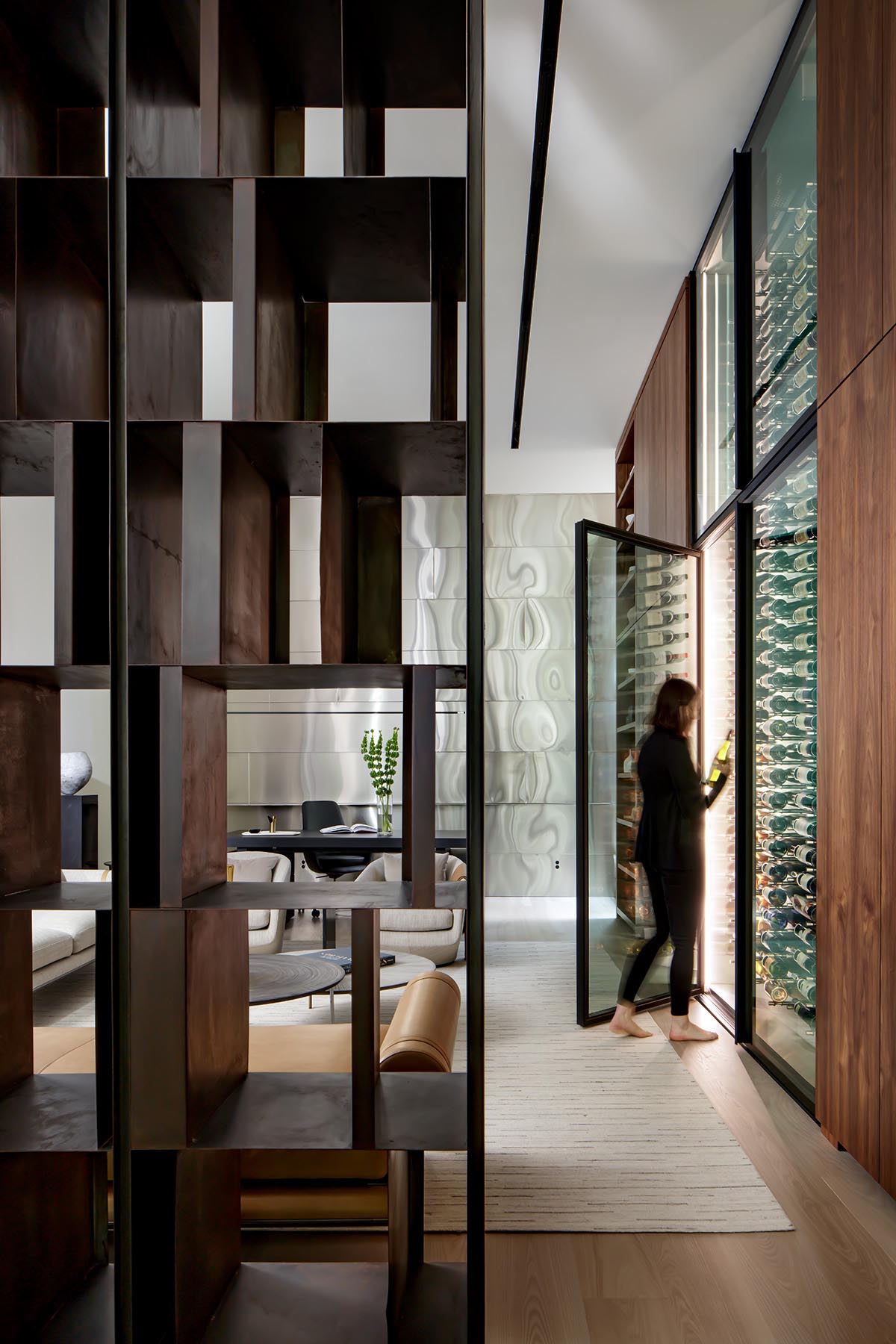 A walnut accent wall showcases a pair of floor-to-ceiling, temperature controlled wine fridges,