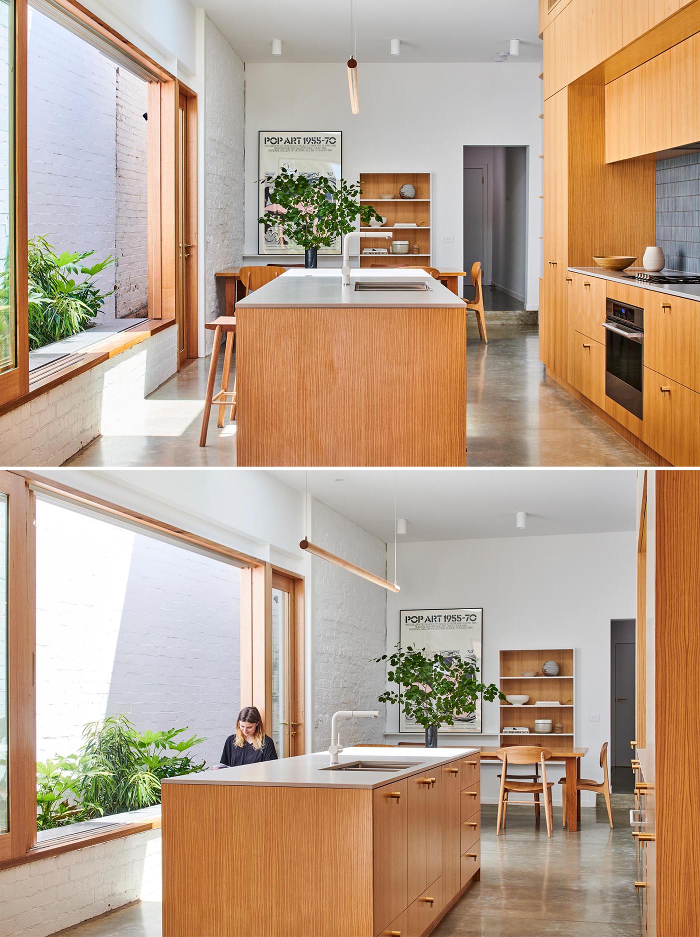 A modern wood kitchen with a large window open to a small garden, gray tiles, an island, open shelving, white countertop, and built-in wine storage.