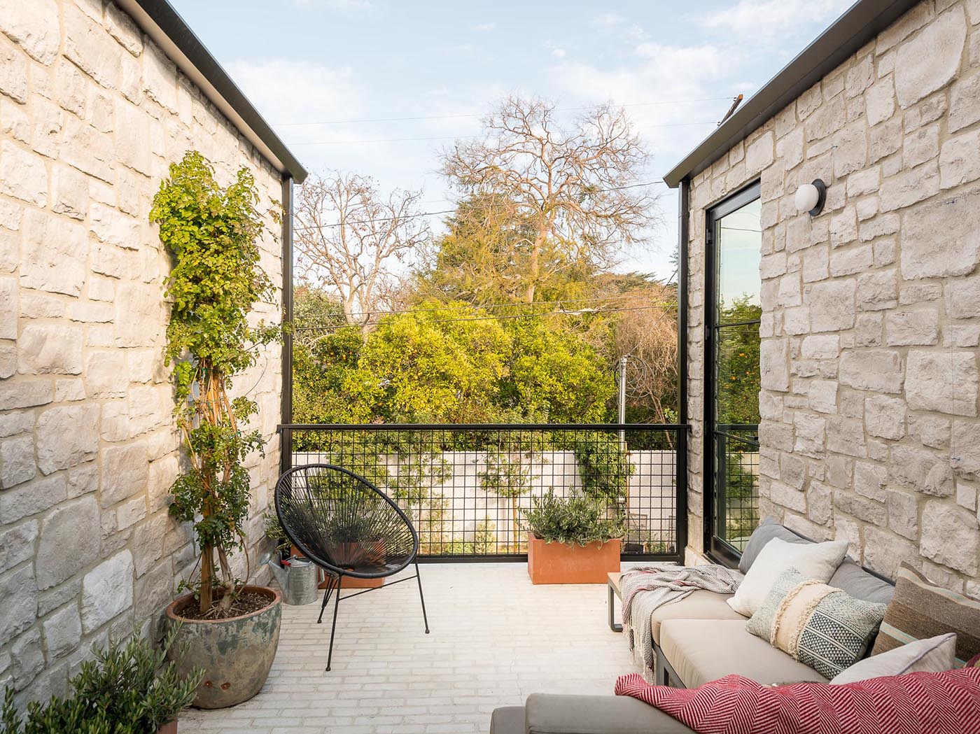 A private patio with a lounge and planters.