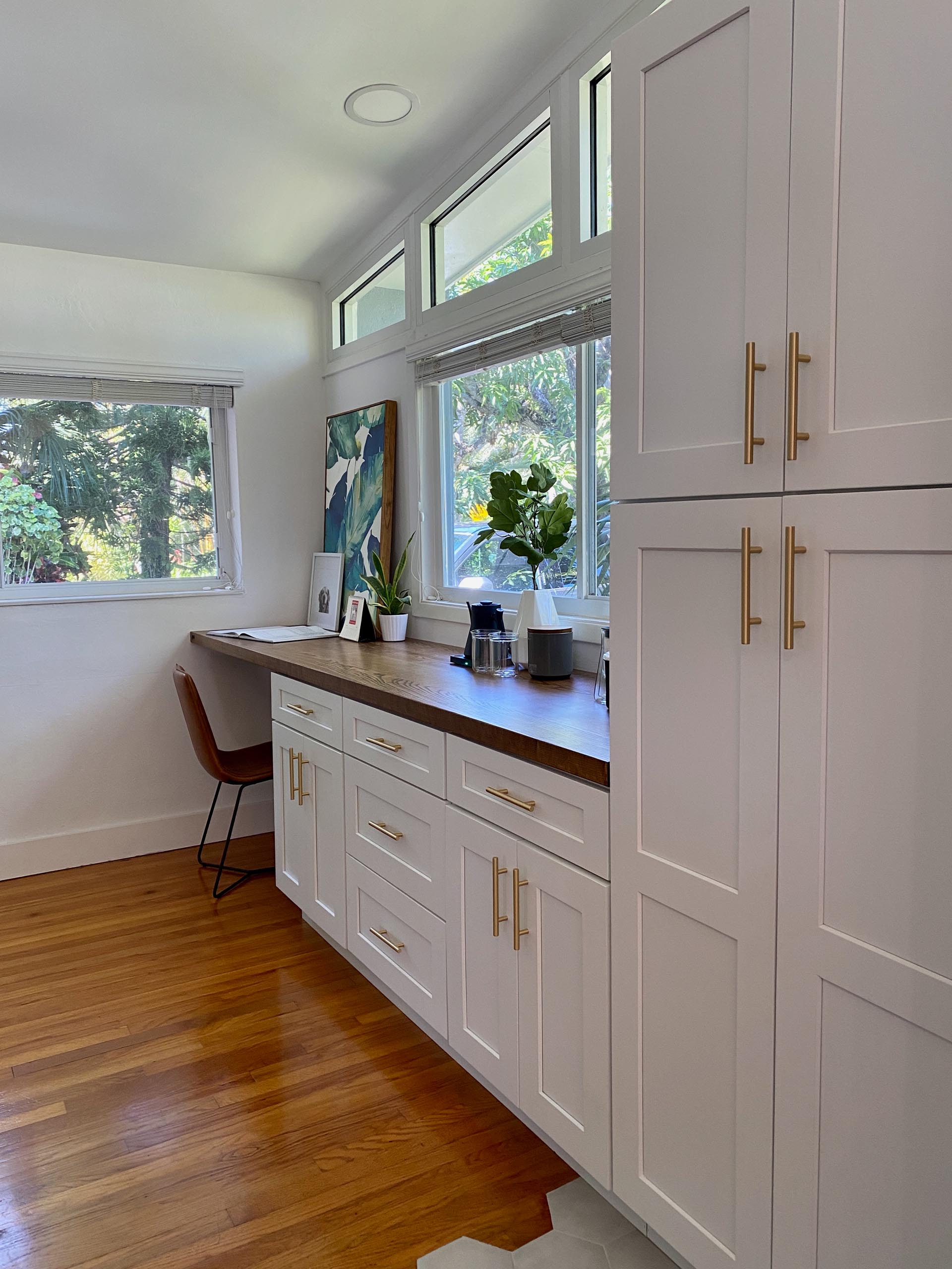 The kitchen cabinets continue along the wall and a wood countertop has been introduced to create a home office and coffee station.