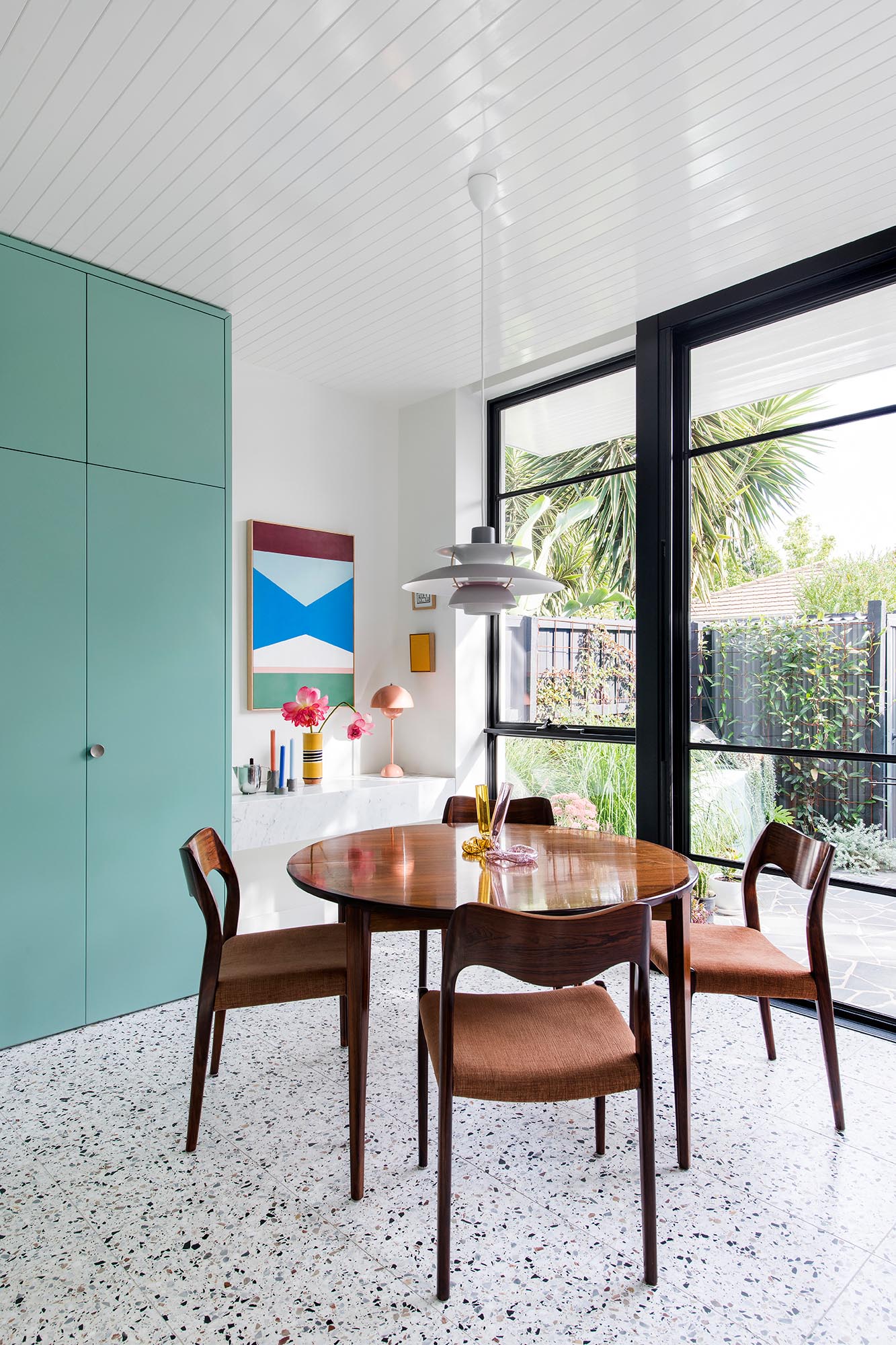 A round mid-century modern wood dining table and chair set.