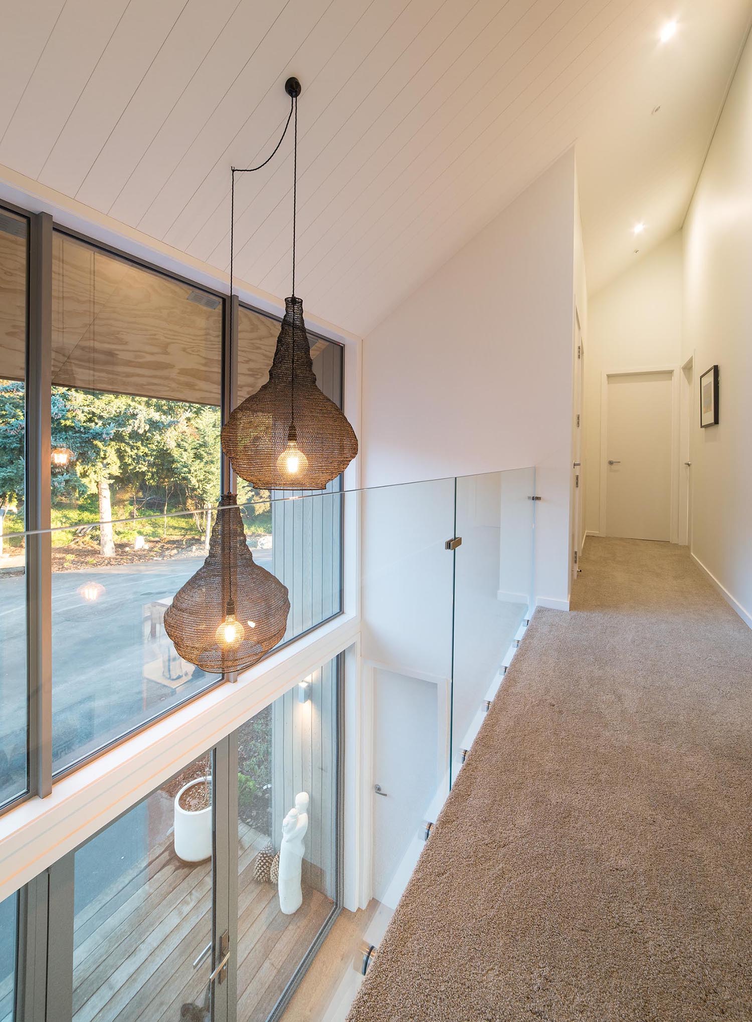 A barn-inspired home with an open hallway and balcony that overlooks the entryway below.