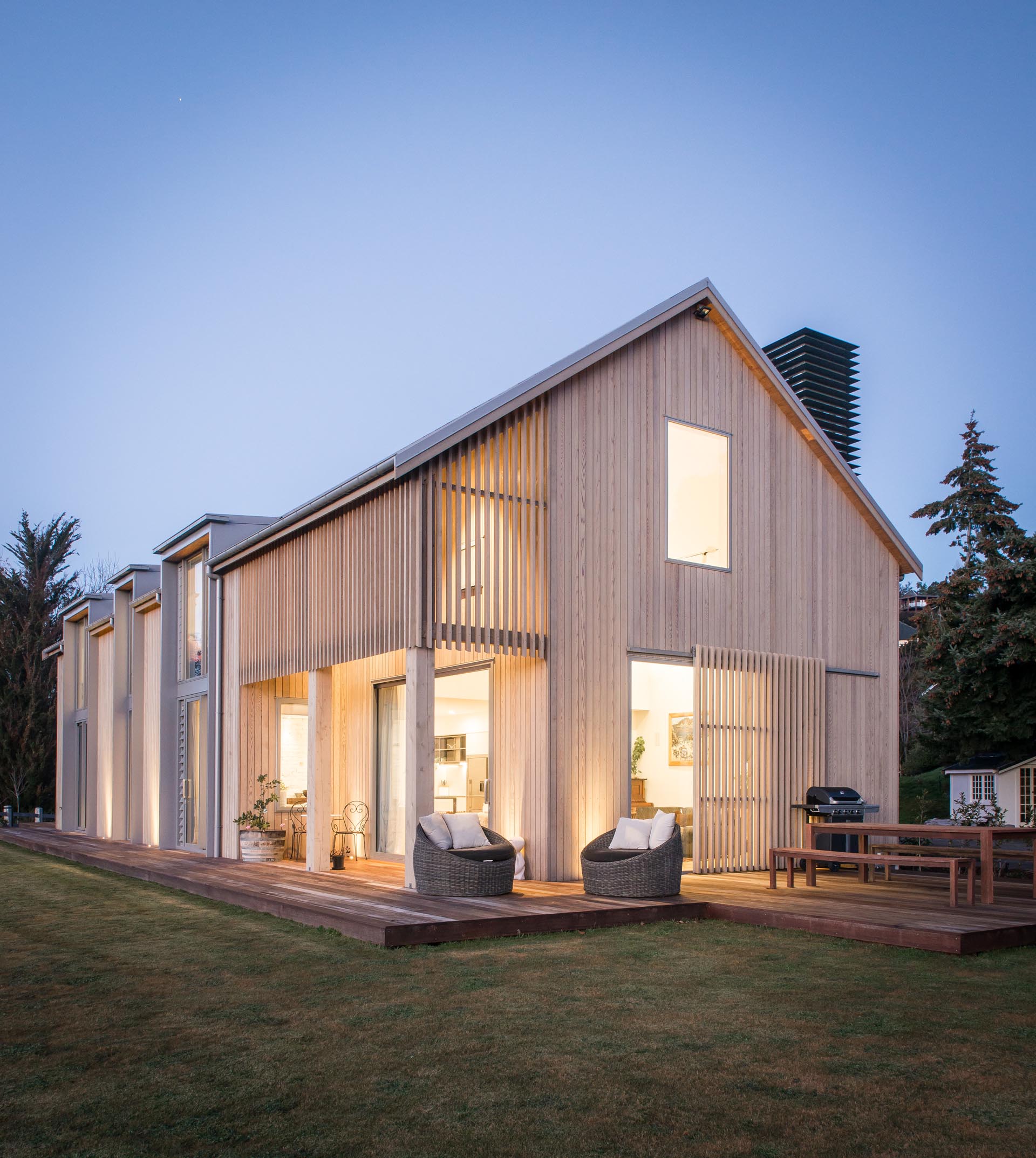A contemporary barn-inspired home  with wood cladding and a wrap around deck.