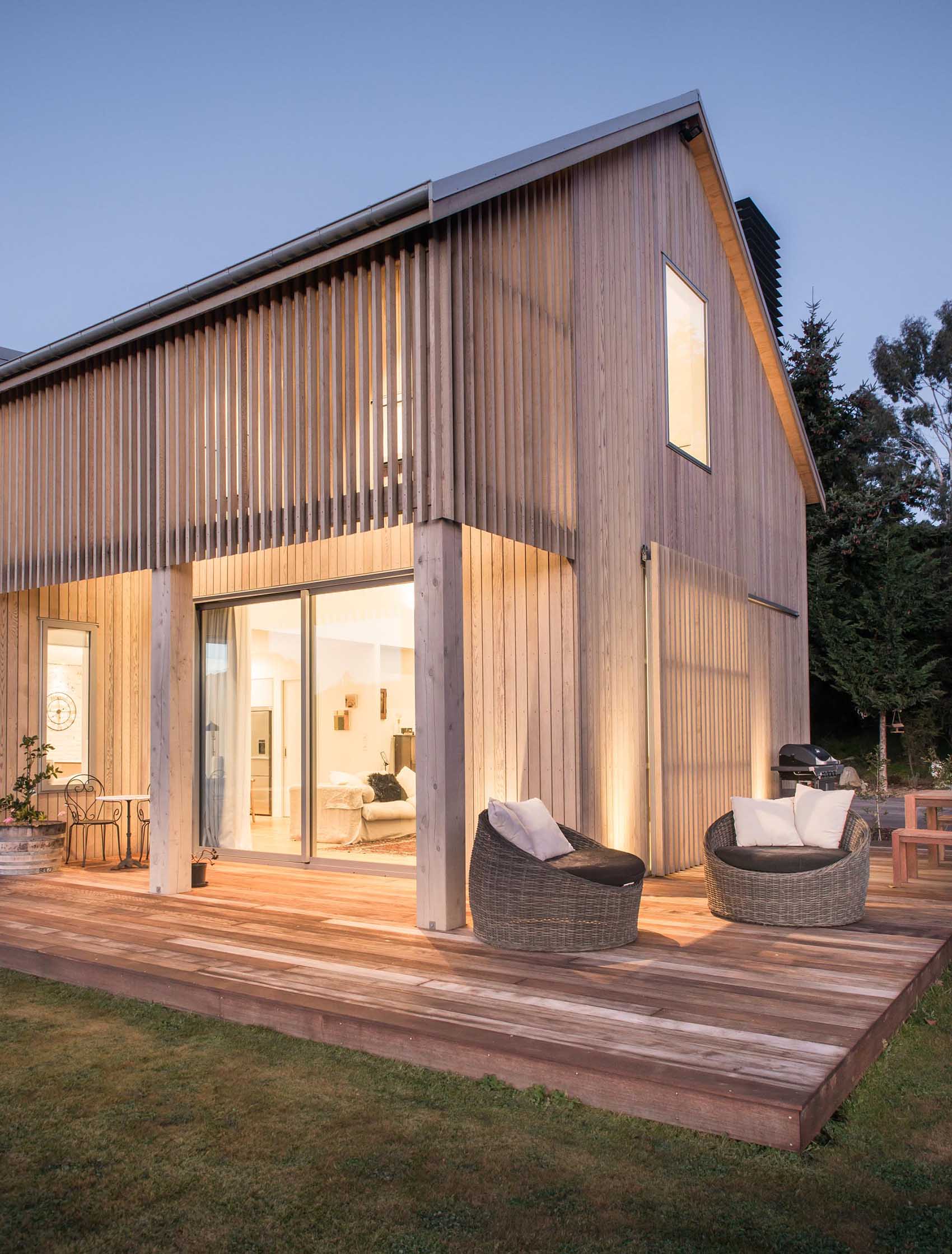 A contemporary barn-inspired home  with wood cladding and a wrap around deck.