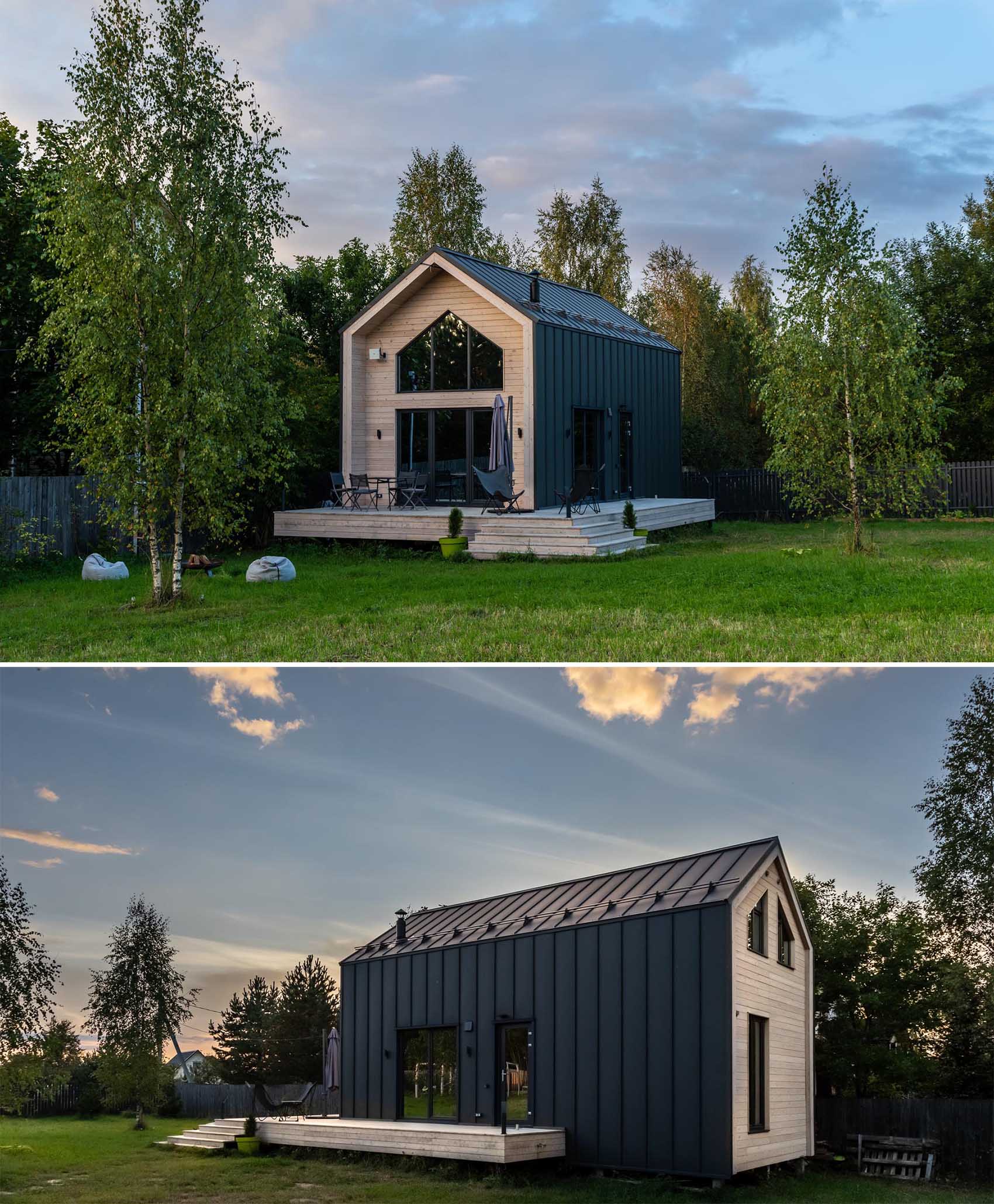 A modern barn-inspired home with a black metal exterior that's accented at each end with tongue and groove wood siding.