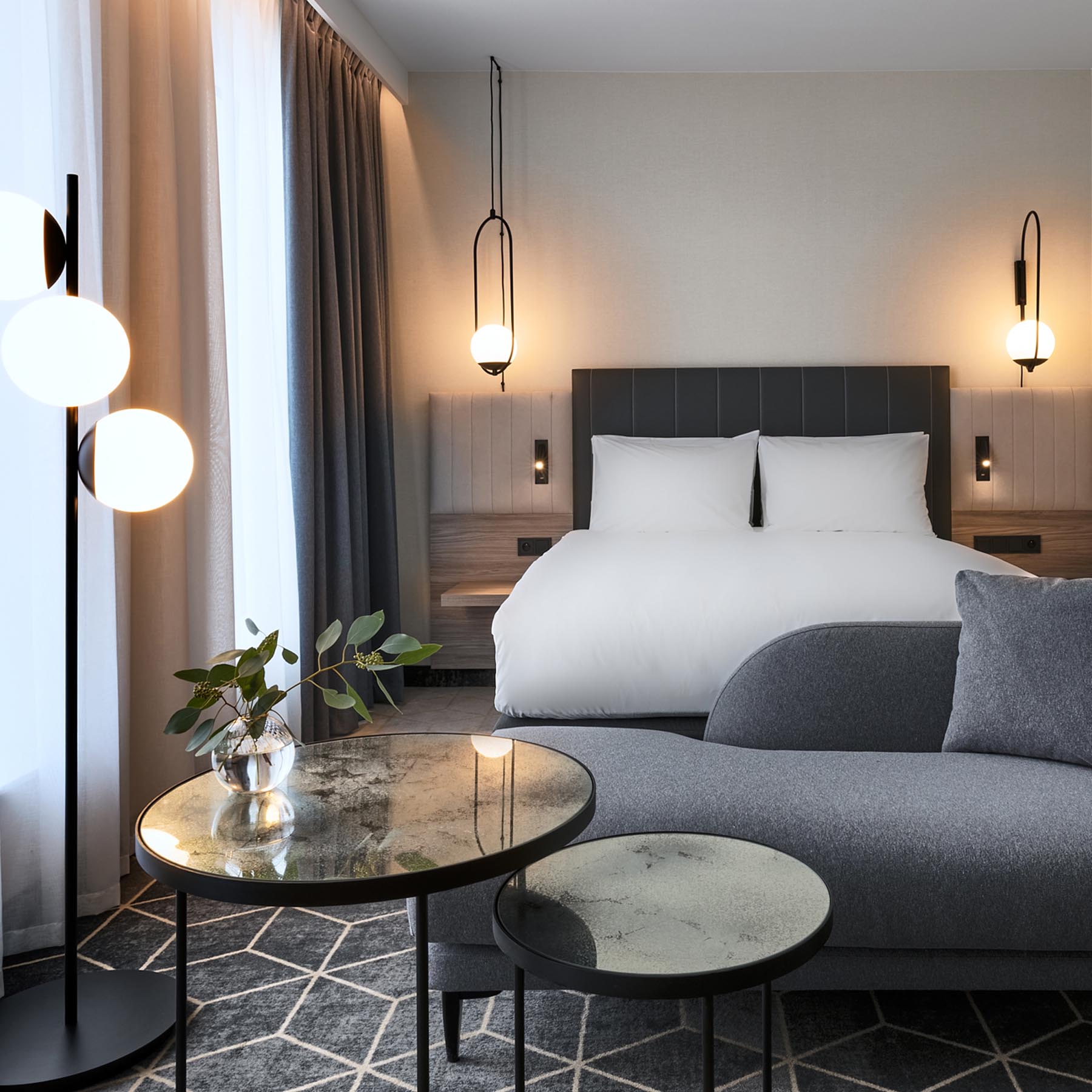 A hotel room with a gray, white, and wood interior.