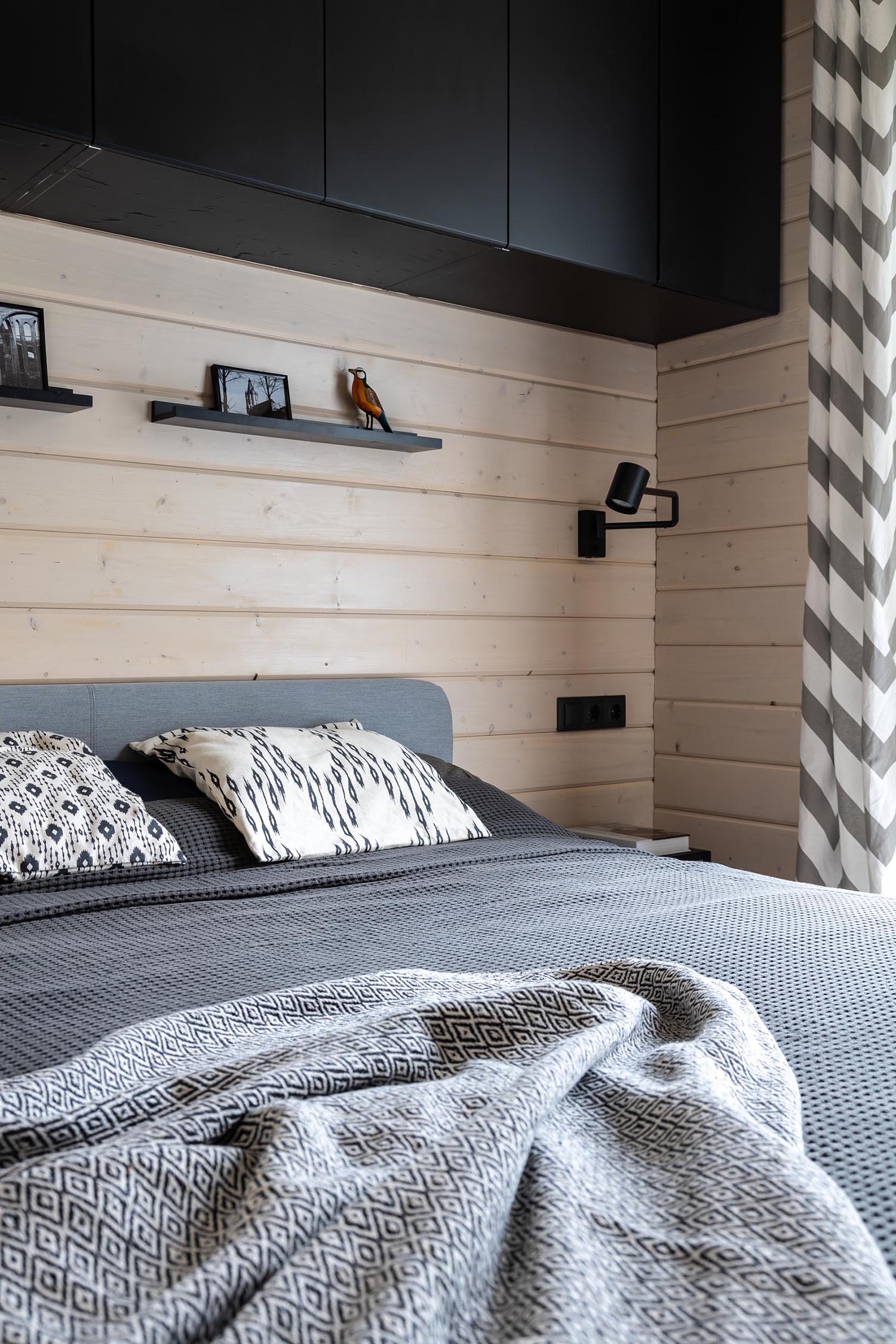 A modern barn-inspired bedroom with tongue and groove wood siding and black accents.