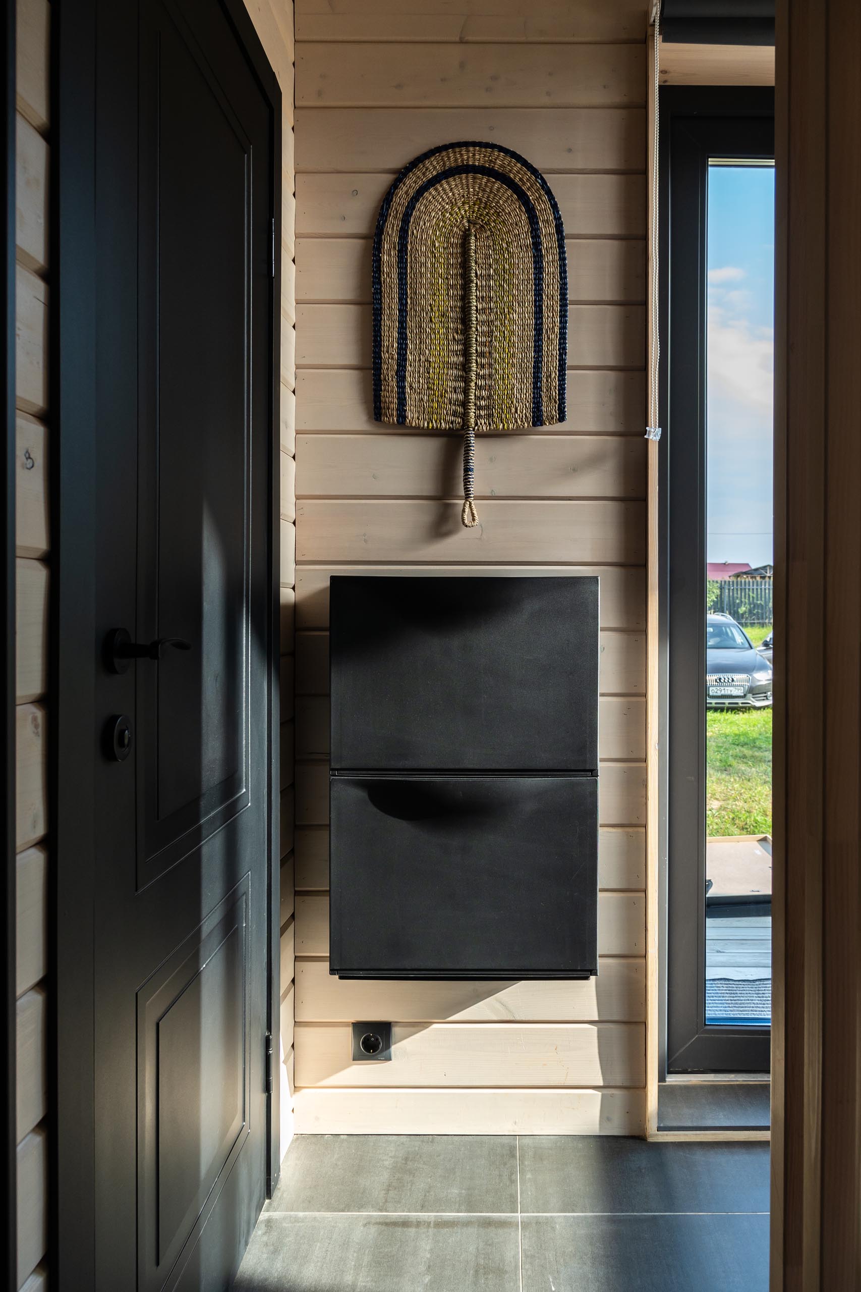 A modern barn-inspired entryway with tongue and groove wood siding and black accents.