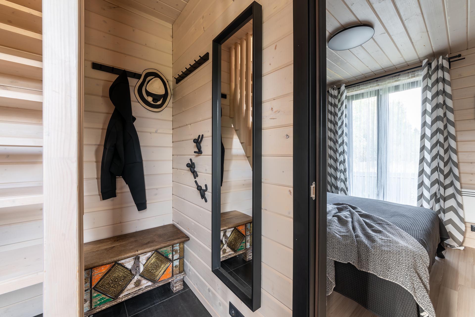 A modern barn-inspired entryway with tongue and groove wood siding and black accents.