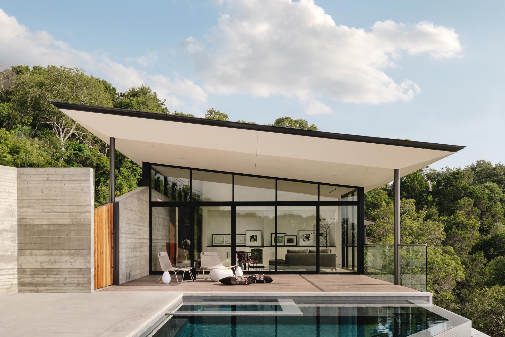 The boomerang shape of the home accentuate the natural curvature of the land, while high walls lined with clerestory windows create a buffer between the busy adjacent road while also balancing light throughout the day.