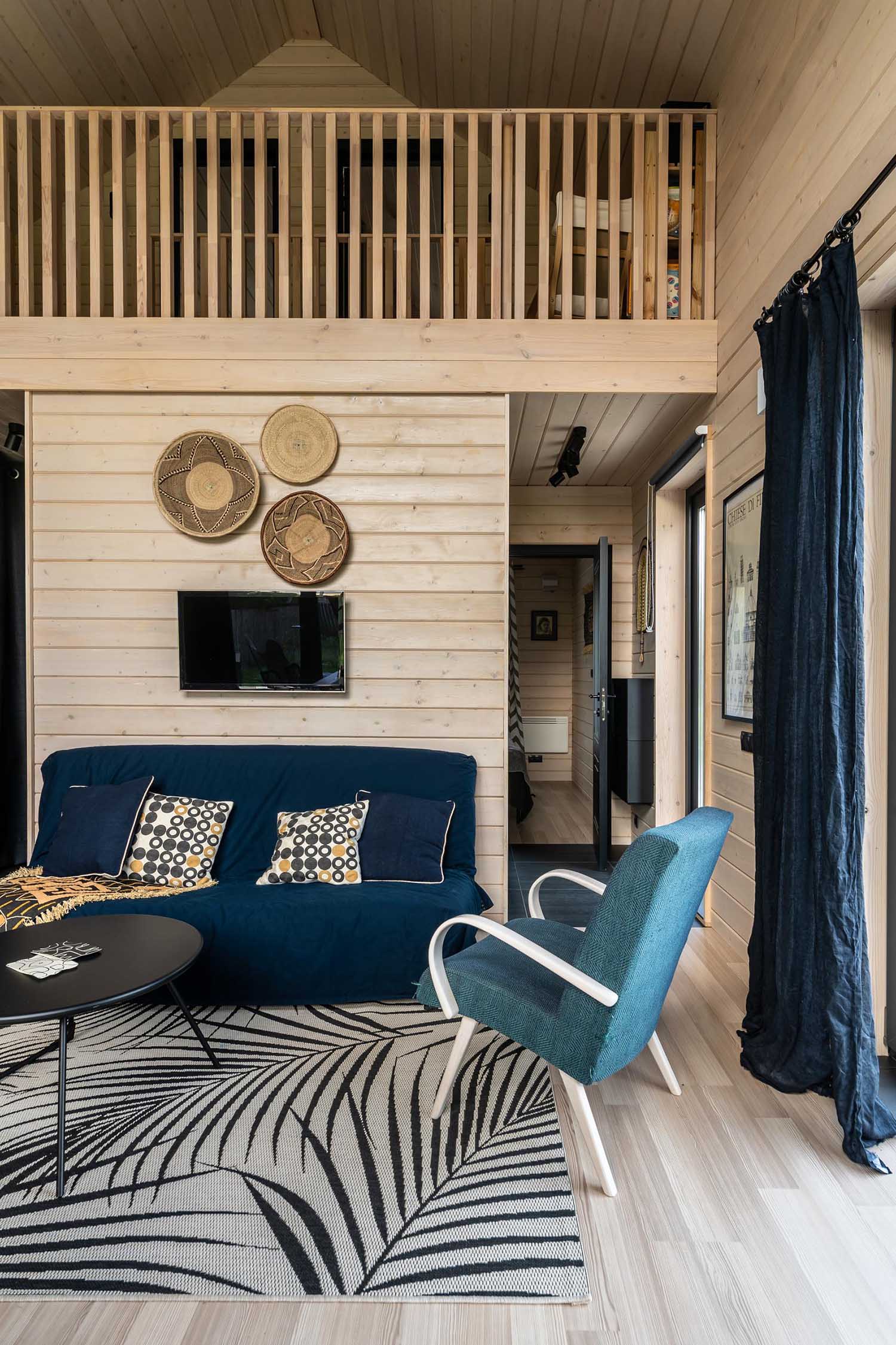 A modern barn-inspired living room with tongue and groove wood siding and black accents.