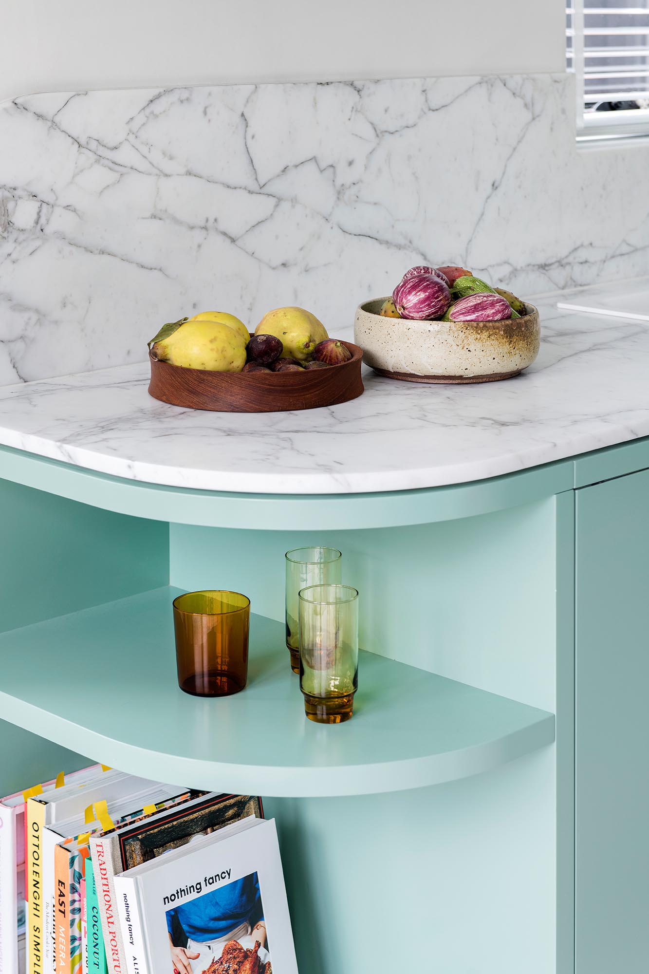 A modern mint green kitchen with Calacatta Statuario countertops, Terrazzo flooring, and white walls and ceiling.