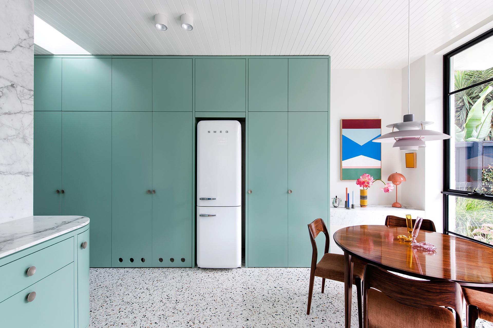A modern mint green kitchen with Calacatta Statuario countertops, Terrazzo flooring, and white walls and ceiling.