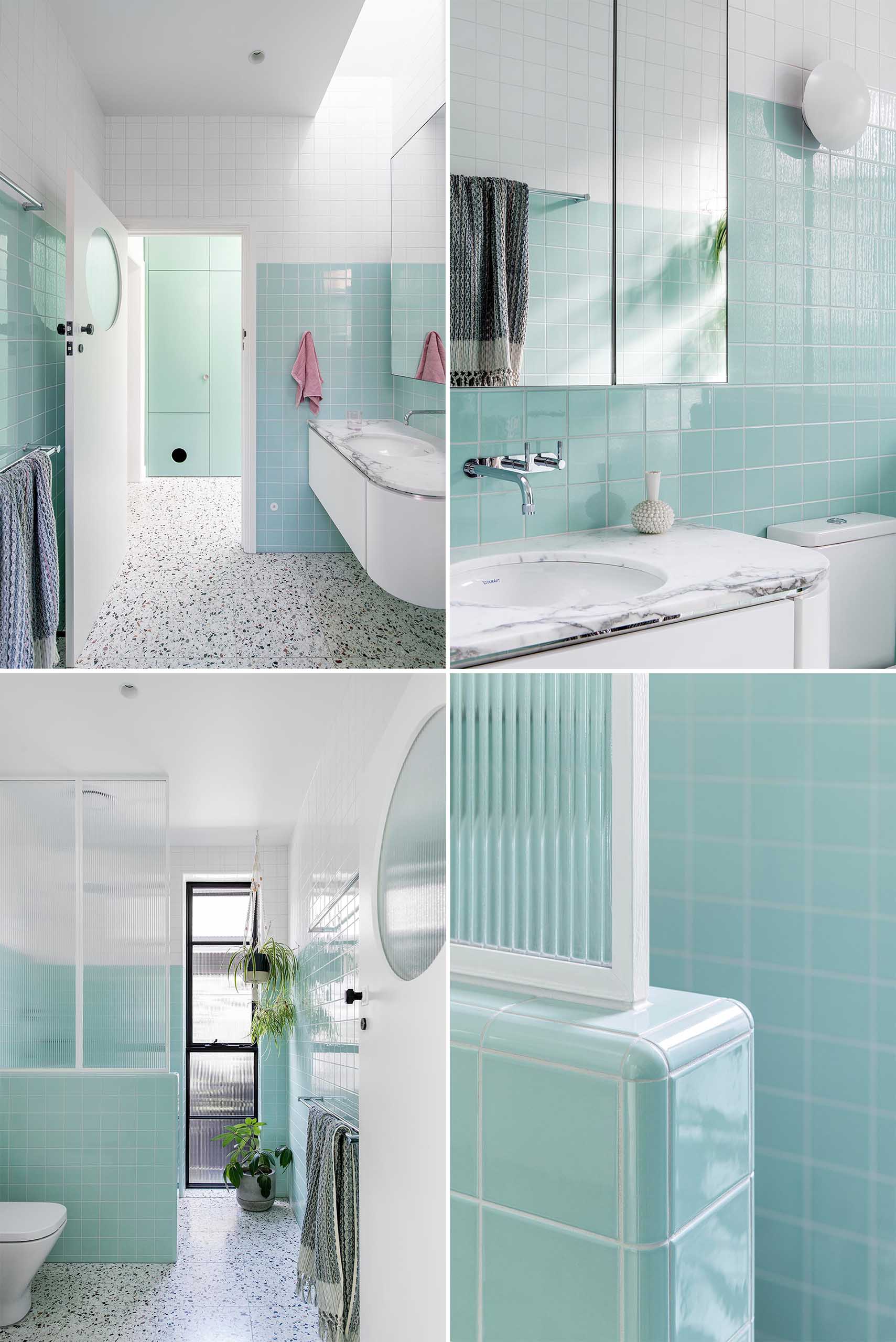 A modern bathroom with white and mint green tiles, a curved vanity, and walk-in shower.