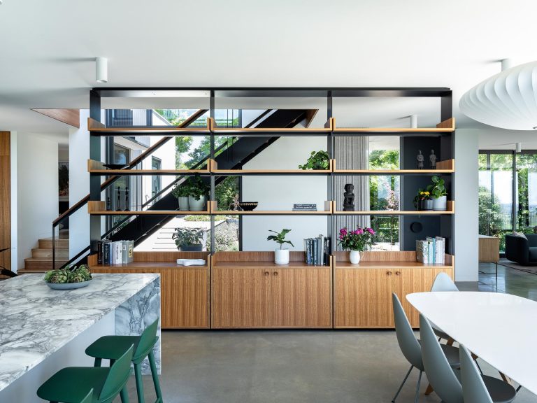 An Open Shelving Unit Is Used As A Partition To Create A Hallway Inside This Home