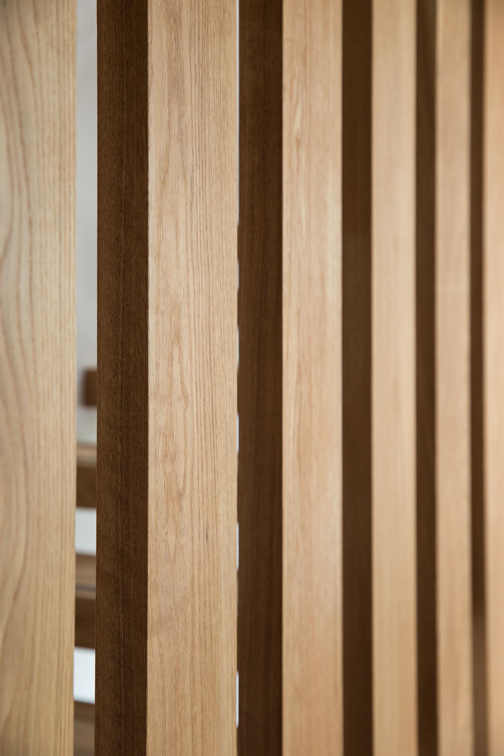 A steel and floating oak staircase with robust timber balusters and embedded stainless steel strips within the stair treads that create a non slip surface.