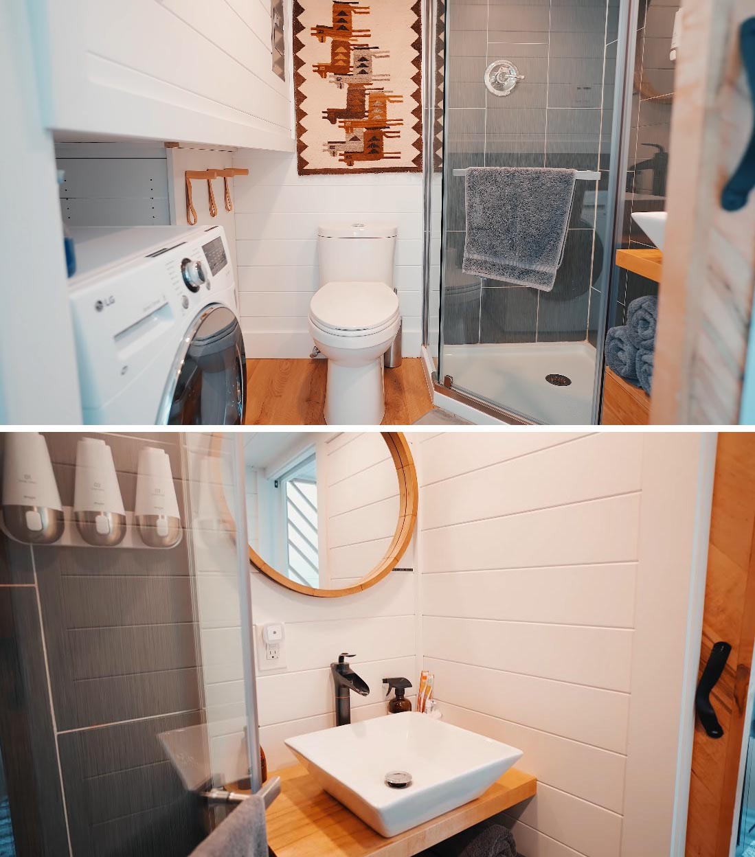 The bathroom of this Scandinavian-inspired tiny home includes a toilet, a shower with vertical gray tiles, a wood vanity with round mirror hanging on the wall above, and a washing machine.