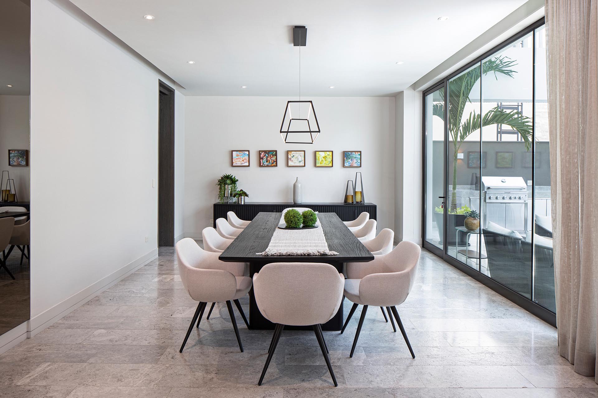 Natural stone flooring can be found on the ground level of this modern home, like in the dining room.