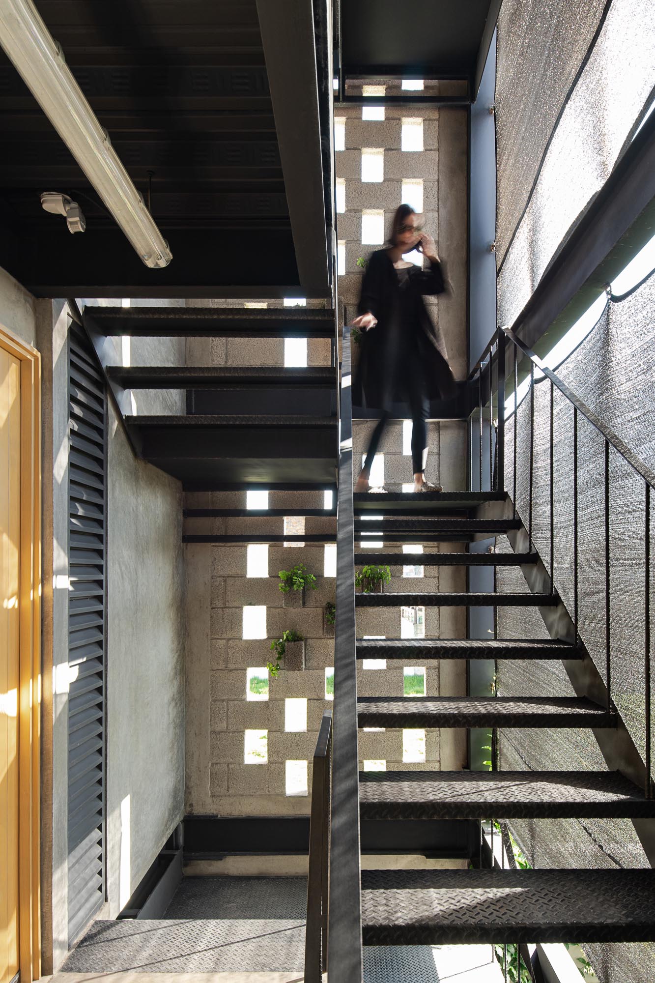 The partially open metal stairs of a small apartment building.