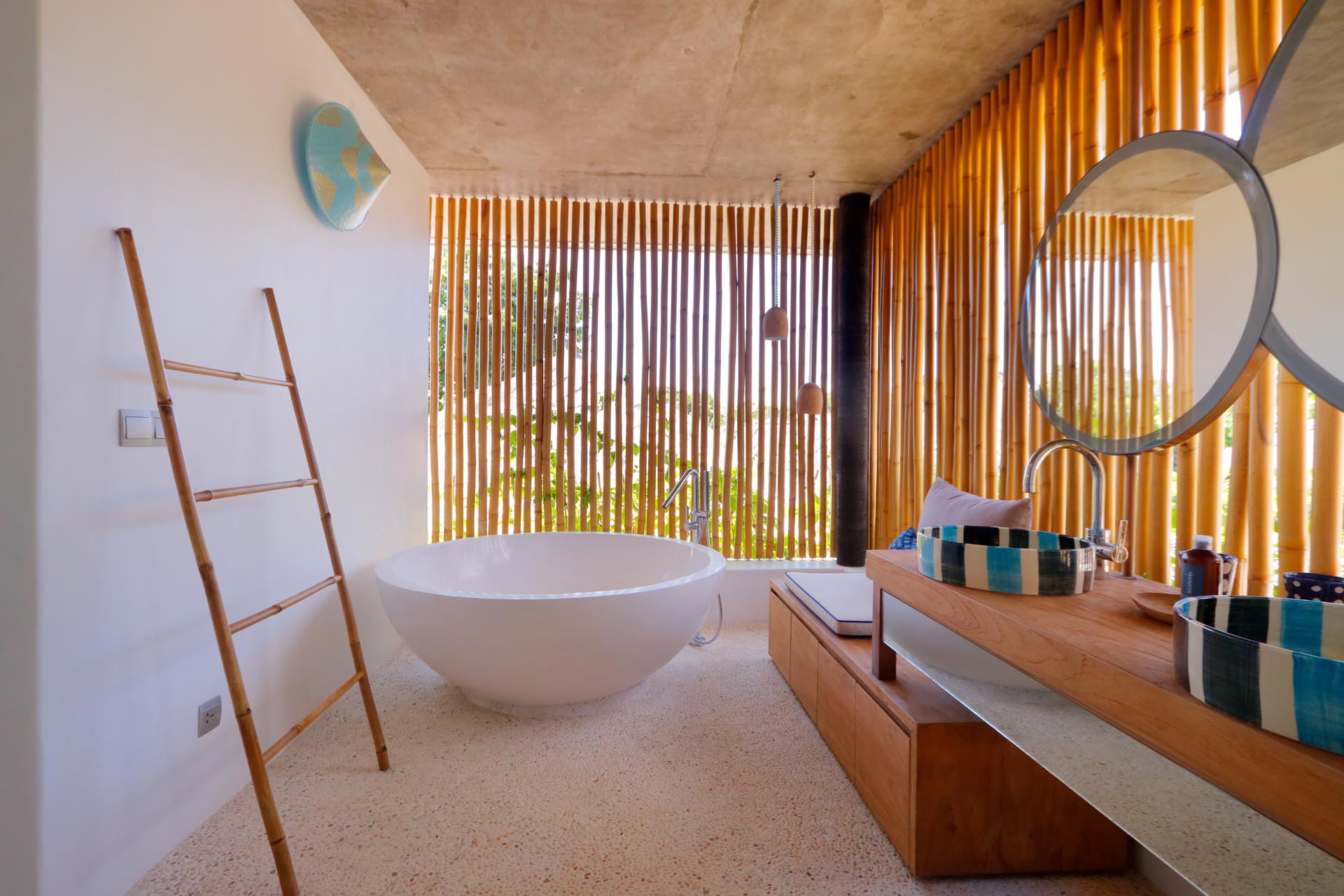 Một phòng tắm hiện đại với các bức bình phong bằng tre bổ sung thêm yếu tố thiết kế tự nhiên cũng mang lại sự riêng tư.