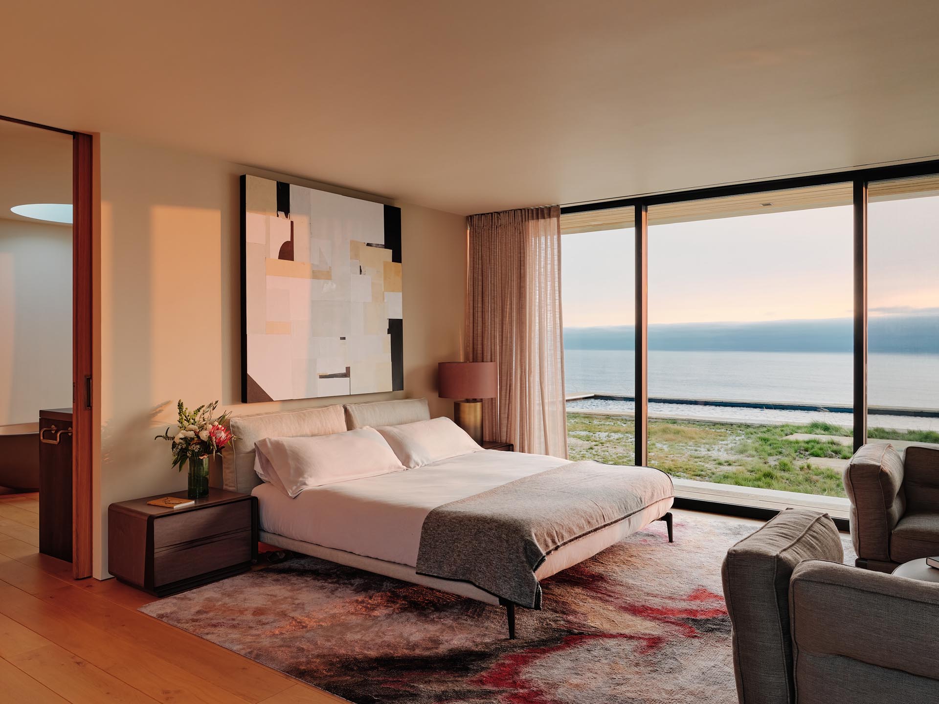 This modern bedroom has a contemporary yet comfortable appearance, with a rug adding a touch of color to the room.