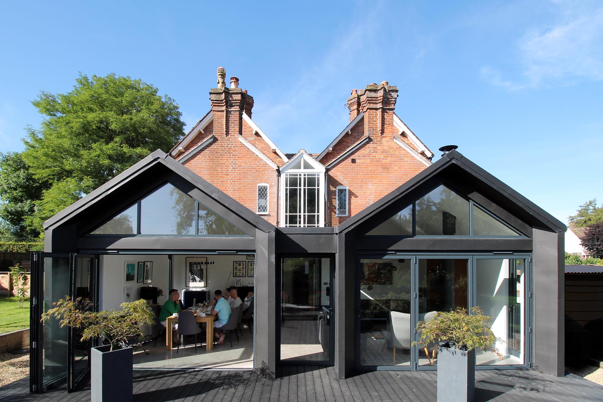 A modern extension with pitched roofs and black in black zinc.