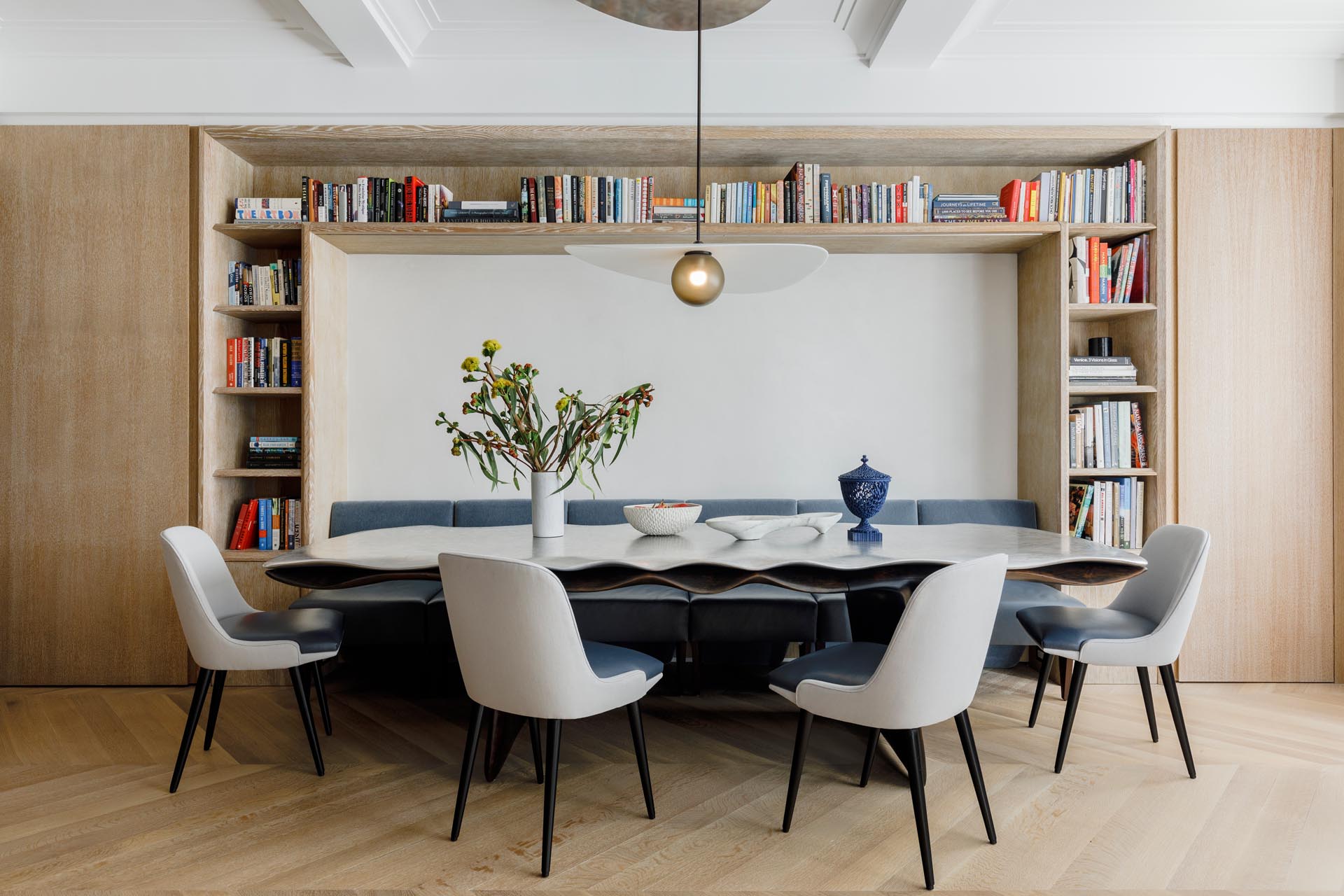 Within this dining room, chairs fit perfectly within the surrounding millwork, allowing them to act as a bench or break apart into chairs.