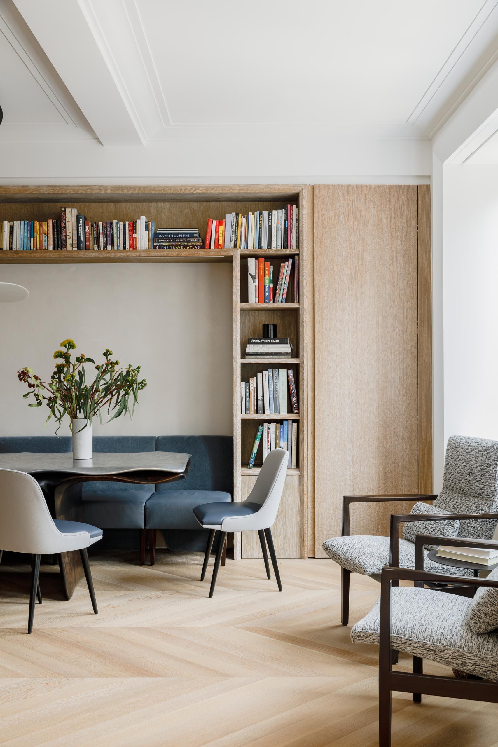 Within this dining room, chairs fit perfectly within the surrounding millwork, allowing them to act as a bench or break apart into chairs.