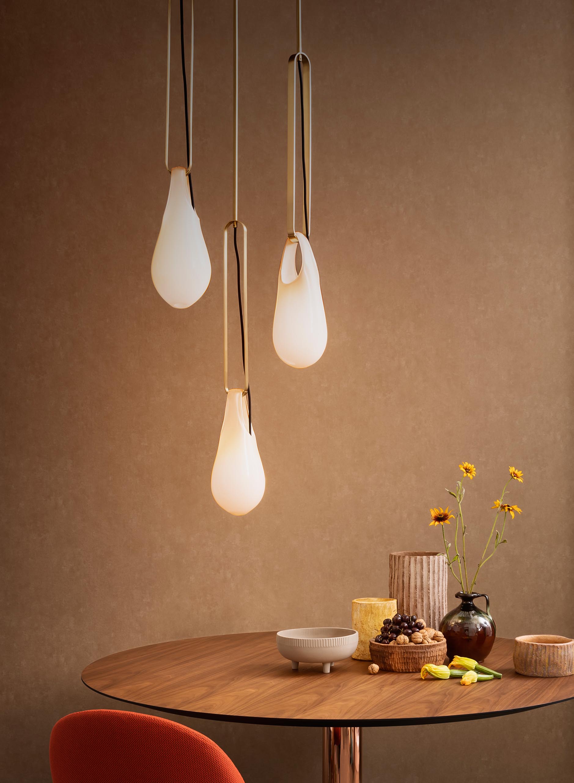 The Hold pendant lights and sconces, are modern handblown glass lights that look like they're hanging from hooks.