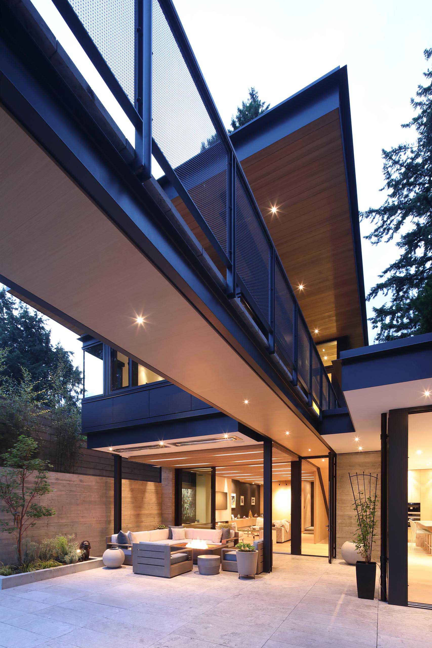 This modern house has a bridge that connects the home to the backyard.