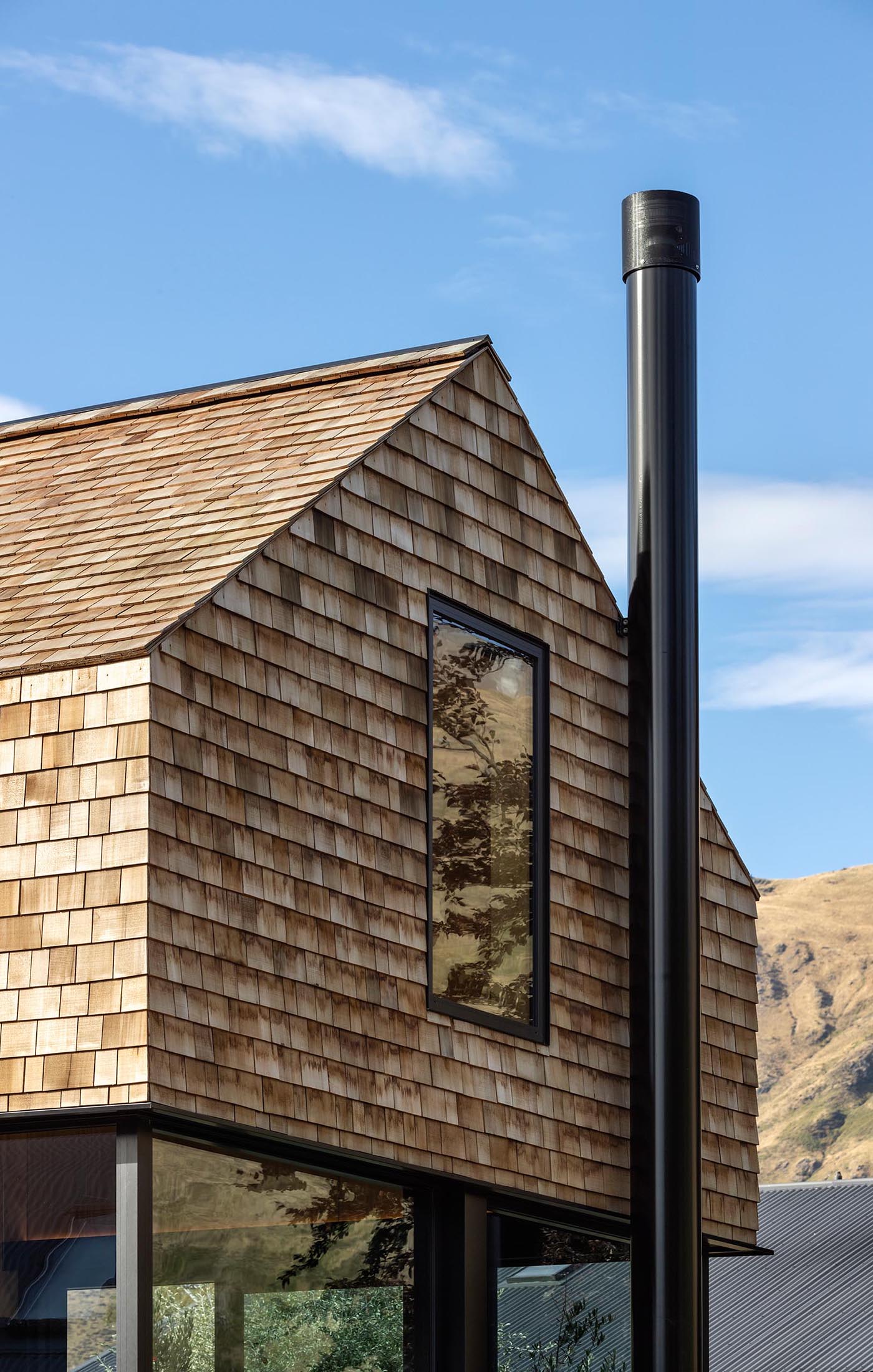 A modern yet small shingle clad home with black accents.