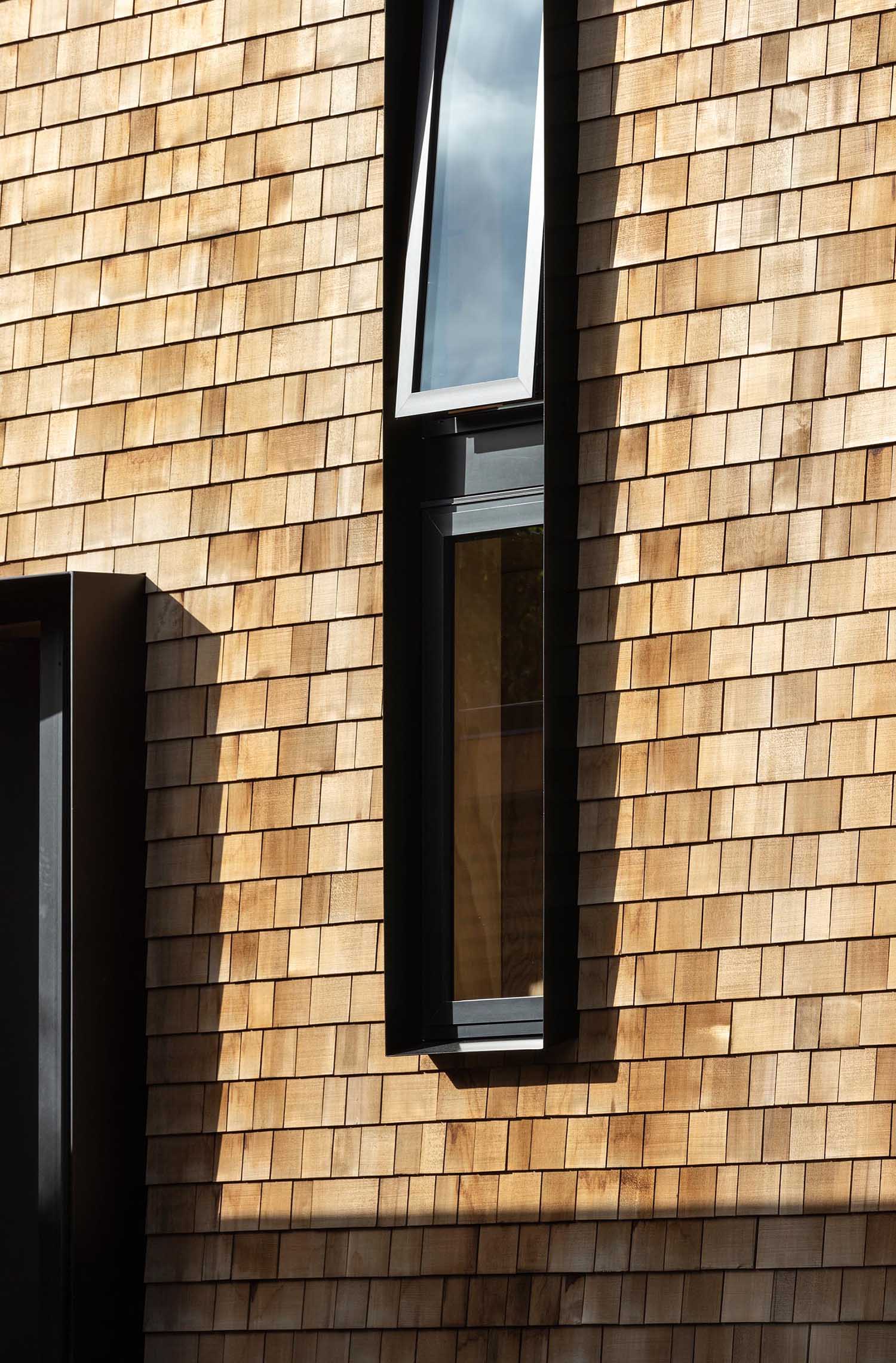 A modern yet small shingle clad home with black accents.