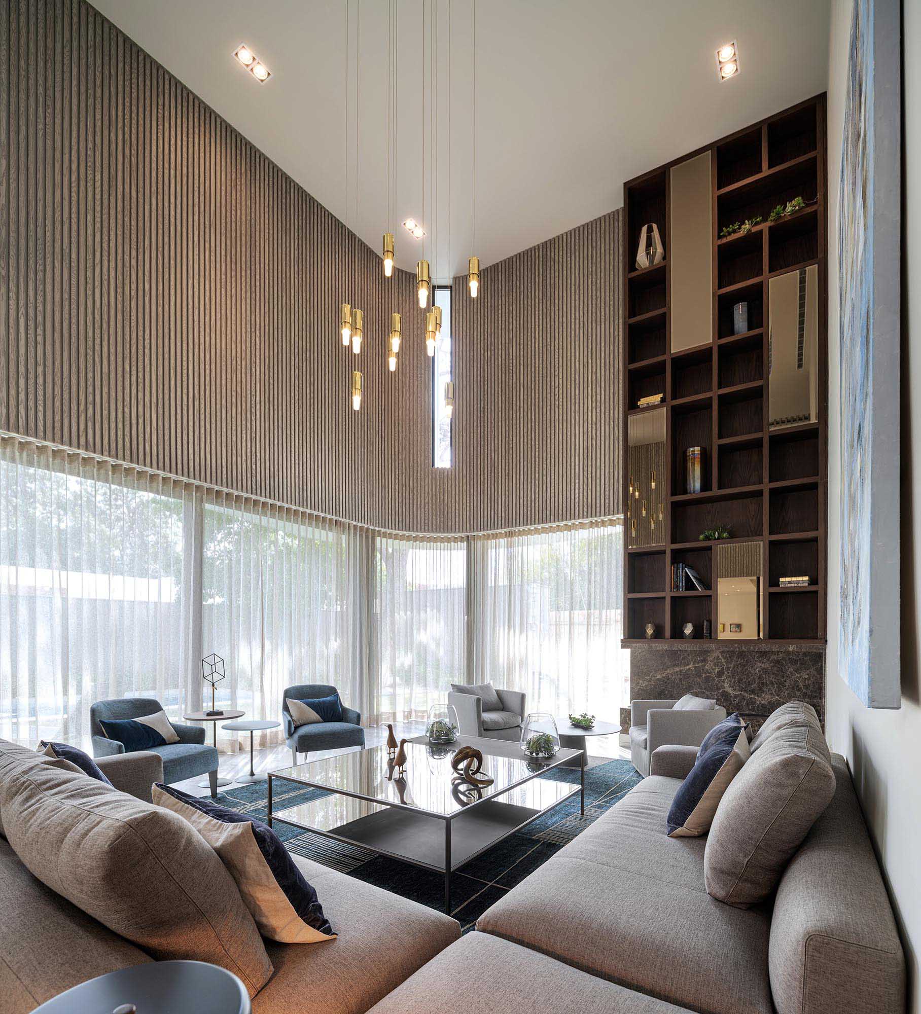 This modern living room opens up to the backyard via two large sliding glass doors that retract into a hidden pocket. Vertical wood paneling echoes the pattern of the exterior pipe screen.