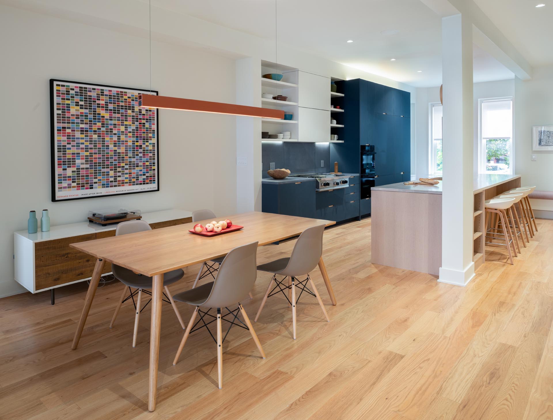 A modern and open plan kitchen and dining area with wood floors.
